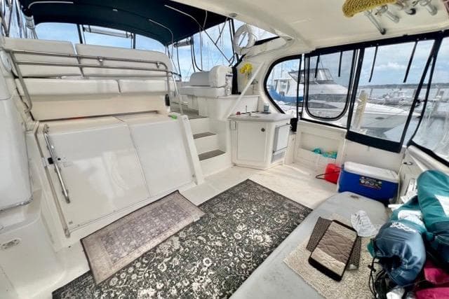 2003 Silverton 43 Motor Yacht interior with seating, rugs, and marina view.