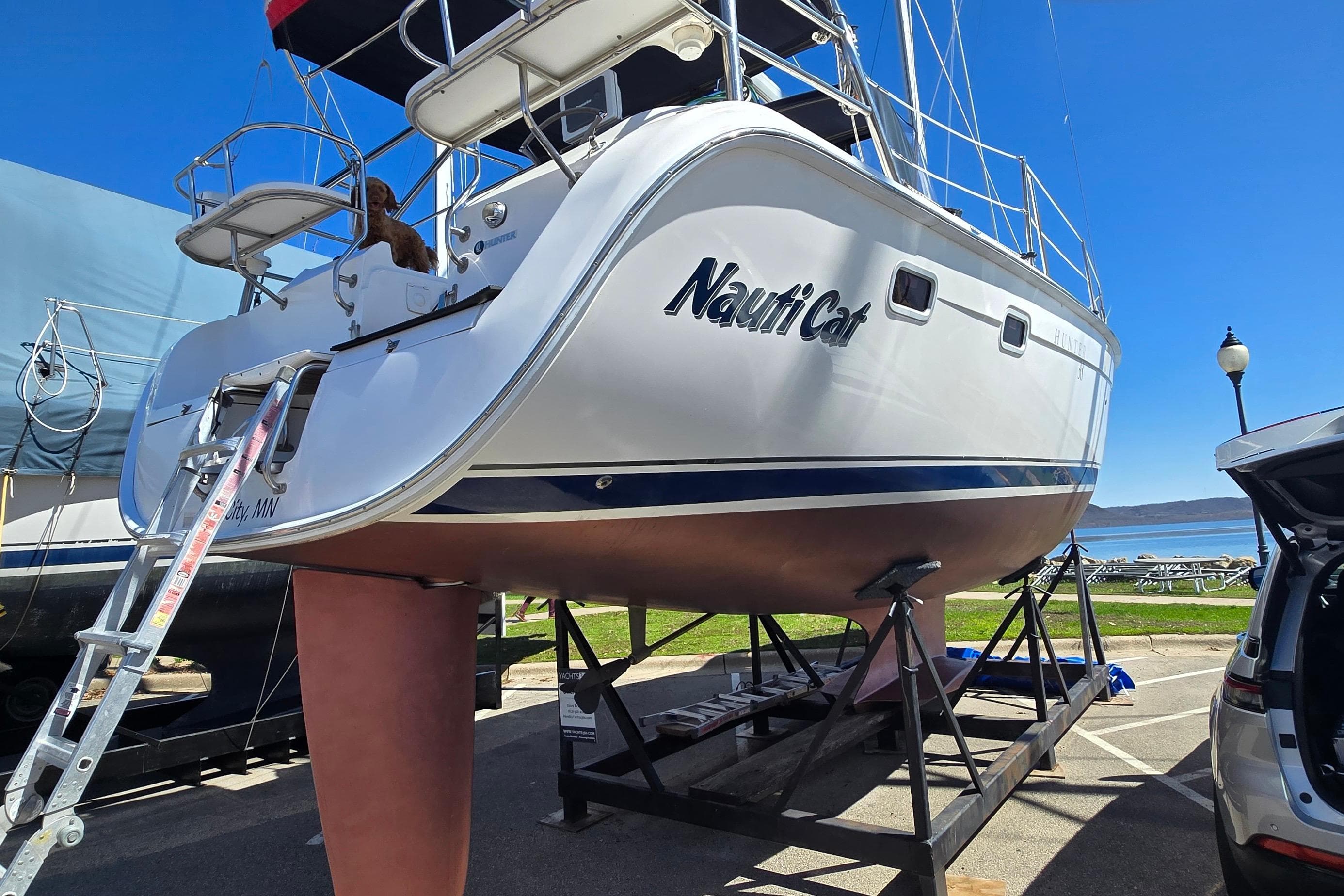 Hunter 38 sailboat from 2005, named "Nauti Cat," on a stand near the water.
