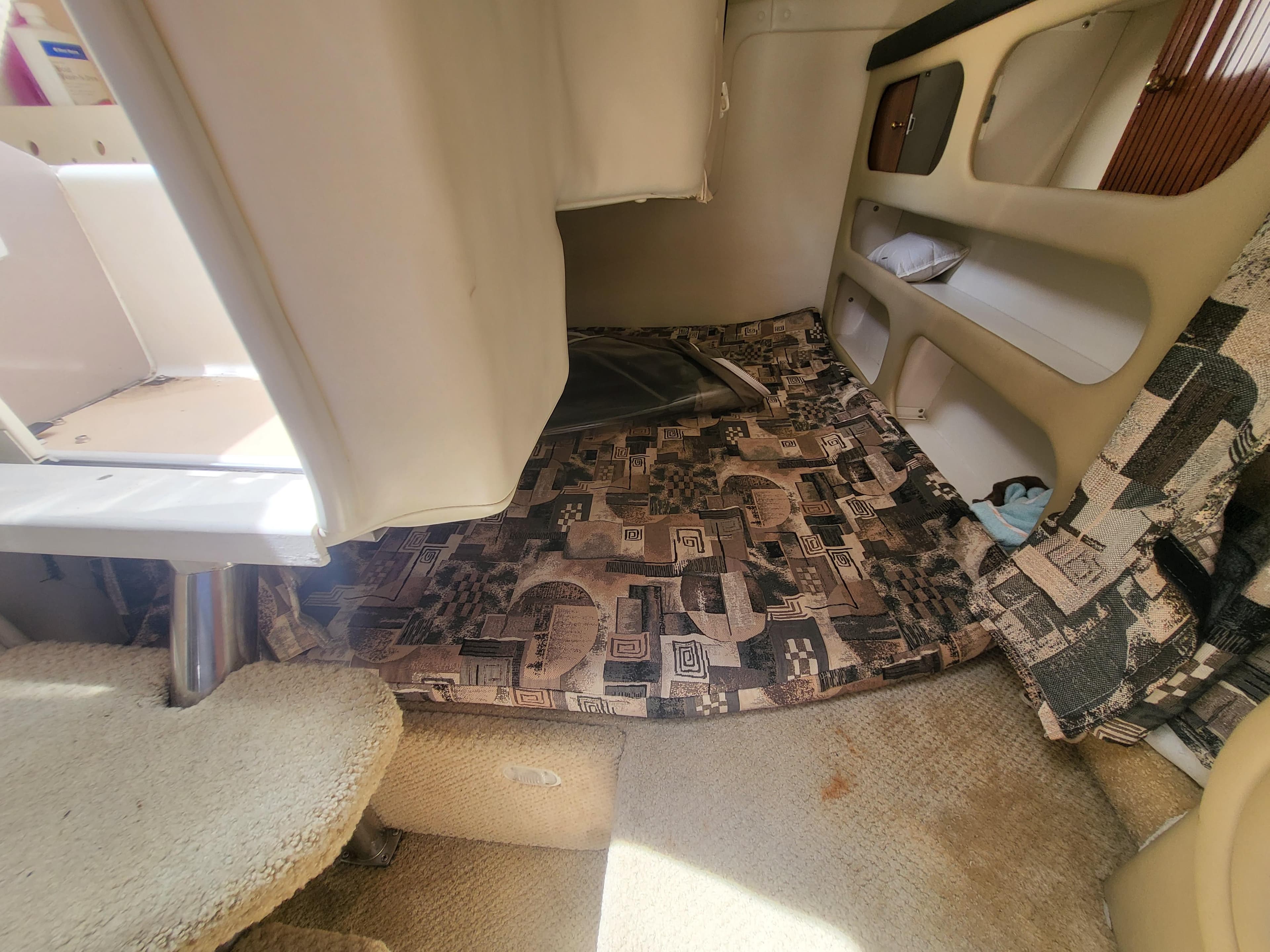 Interior cabin of 2003 Rinker Fiesta Vee 270 boat with patterned bedding.