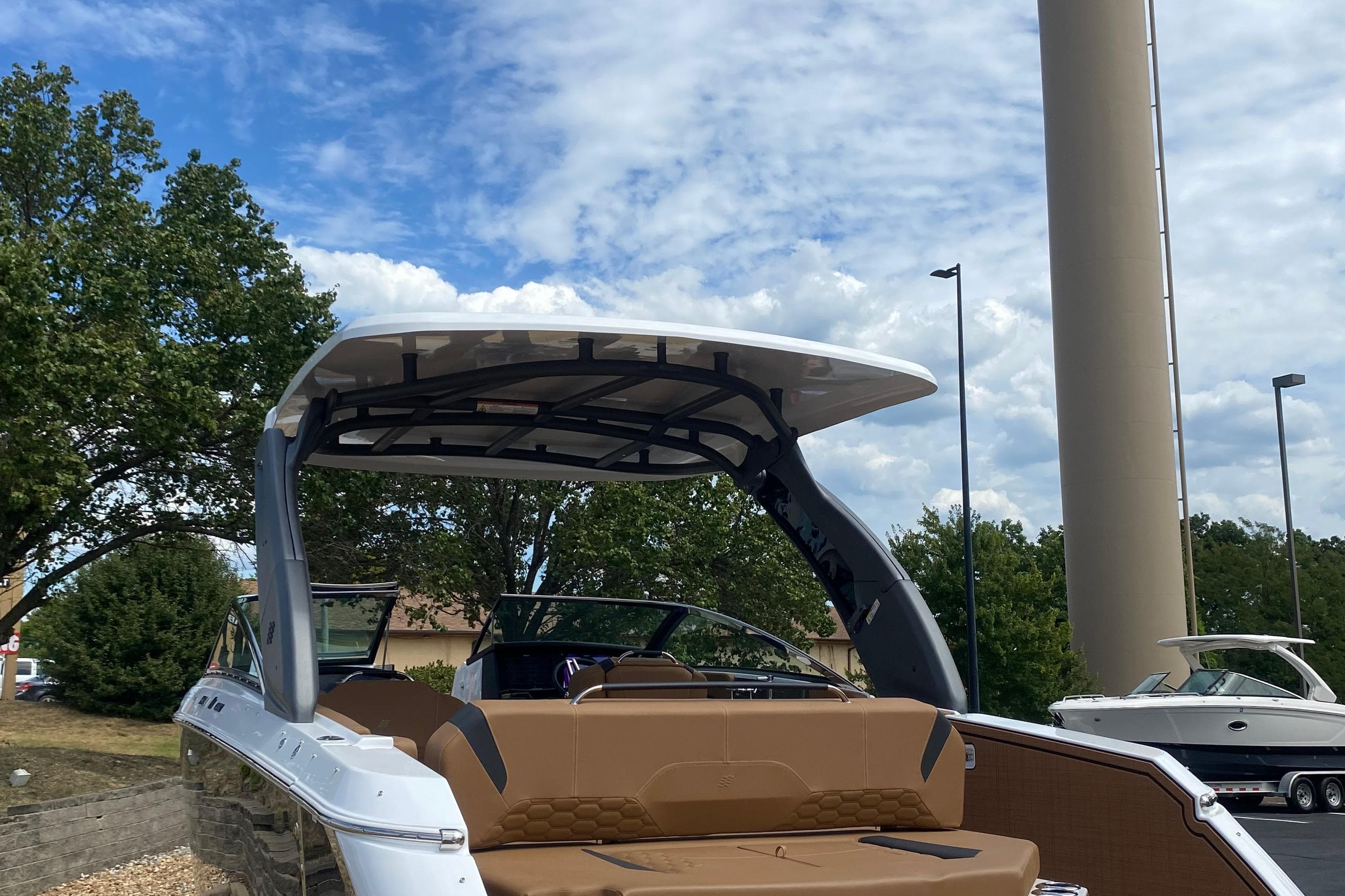 2026 Four Winns H9 boat with sleek design, brown seating, and modern canopy under blue sky.
