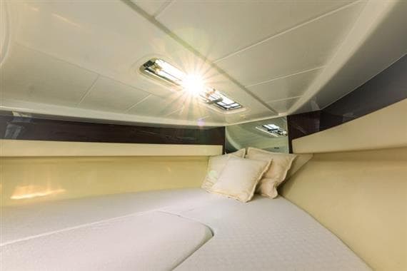 Luxurious cabin interior of 2011 Riva Aquariva yacht with cozy bedding.