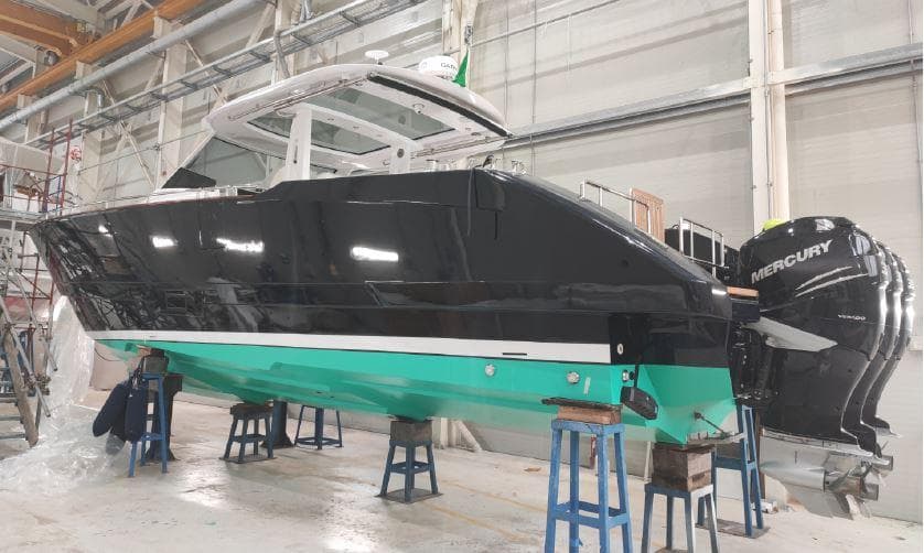 2024 Austin Parker 44 yacht in a workshop, elevated on stands, with Mercury engines.