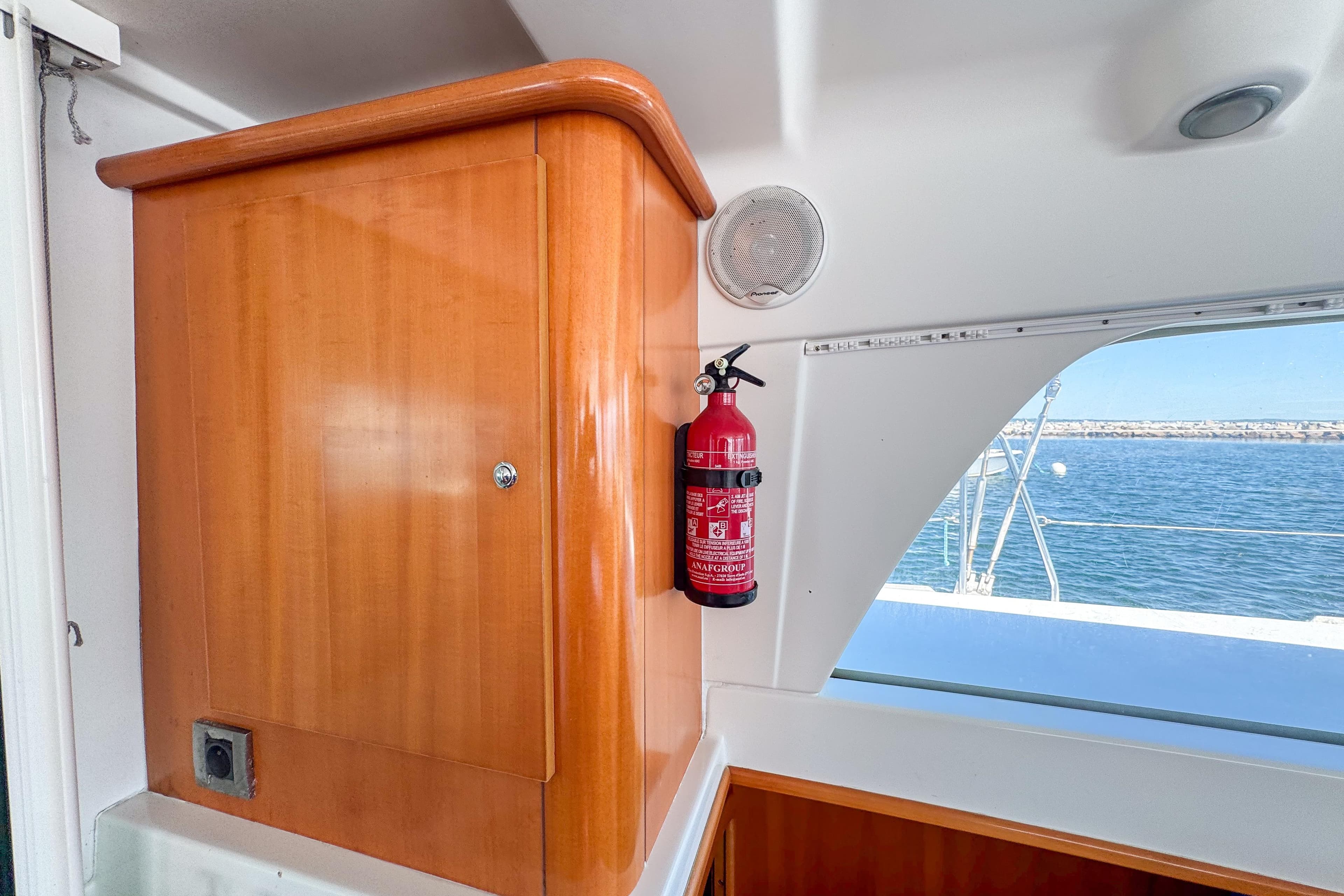 Interior of 2005 Lagoon 440 yacht with wooden cabinet and fire extinguisher.