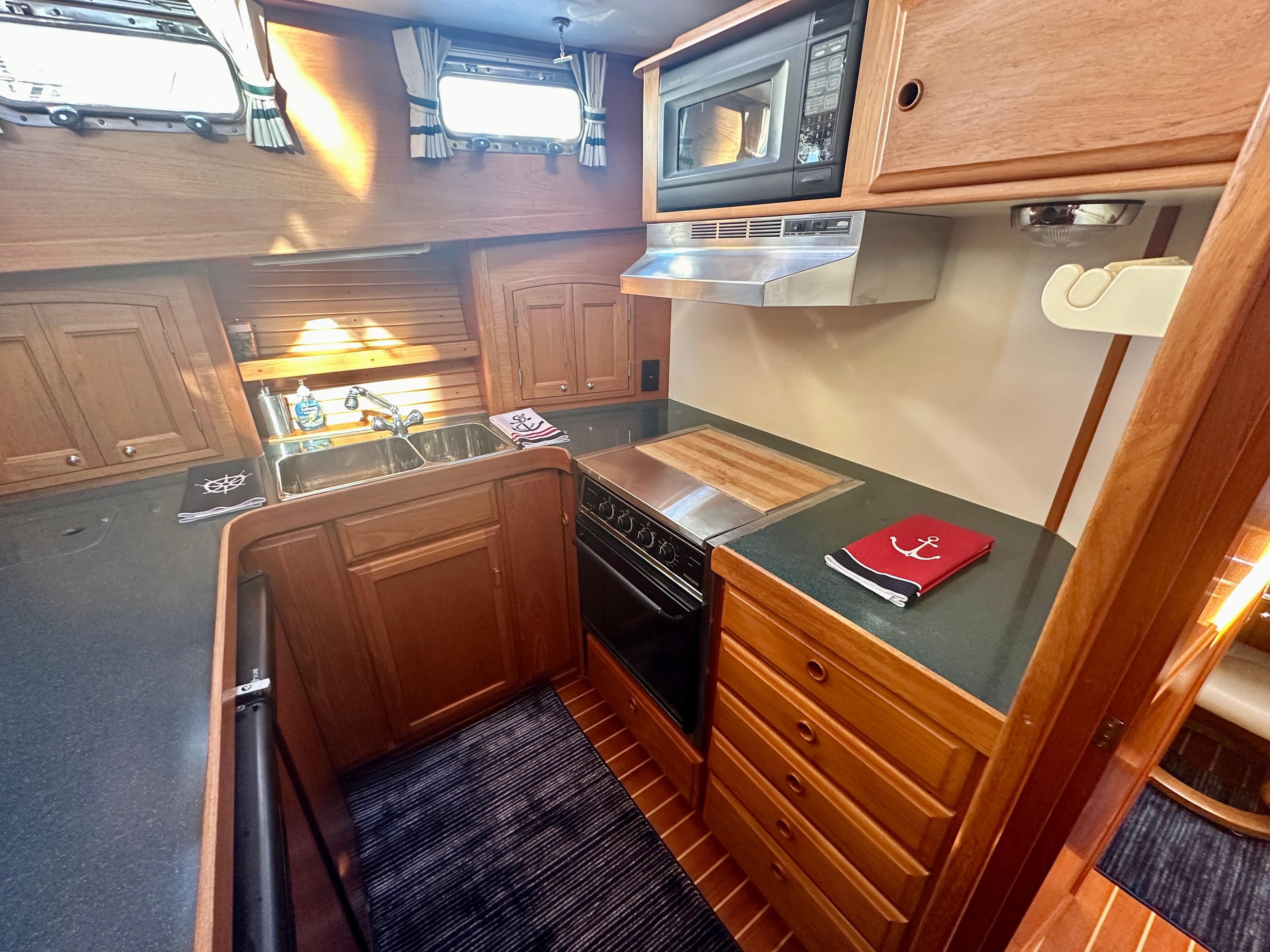 1997 Sabre Cockpit Motor Yacht kitchen with wood cabinetry, stove, and microwave.