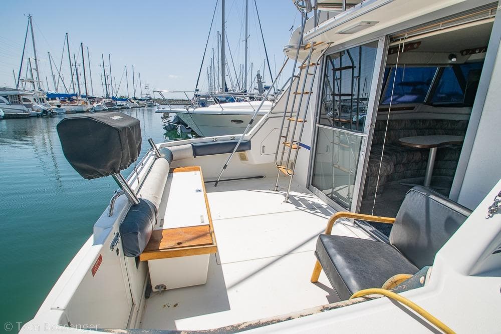 1991 Sea Ray 370 Sedan Bridge yacht docked at marina, featuring spacious deck and seating.