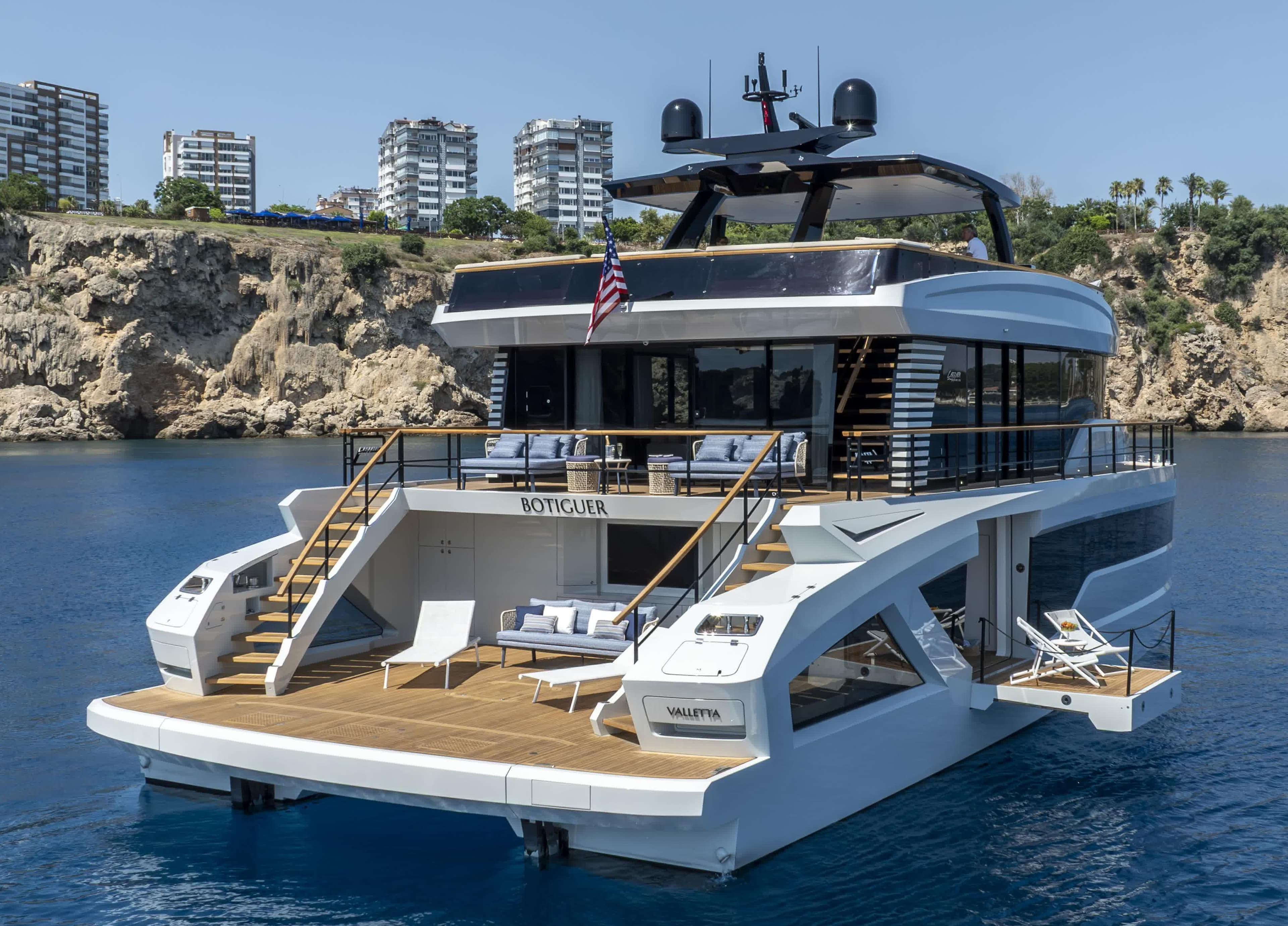 Luxury Lazzara LPC 300 yacht, 2027 model, docked near scenic cliffs and modern buildings.
