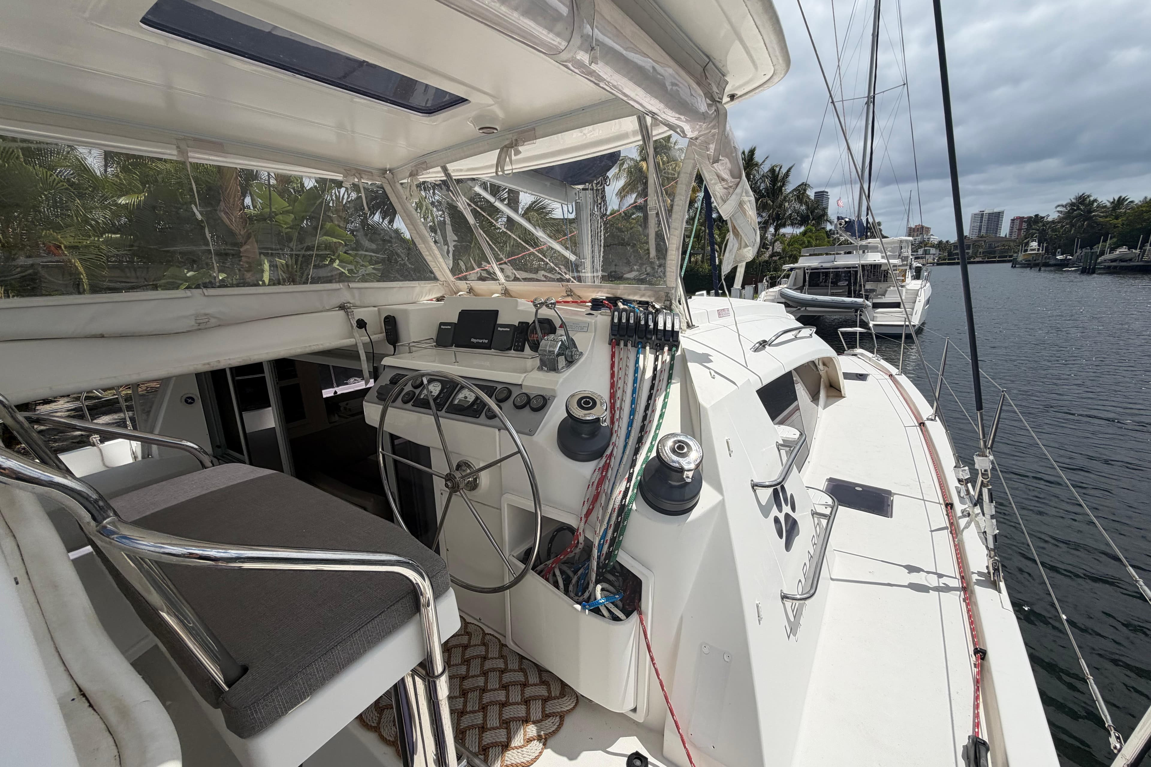 Cockpit view of a 2018 Leopard 40 catamaran docked by a scenic waterfront.