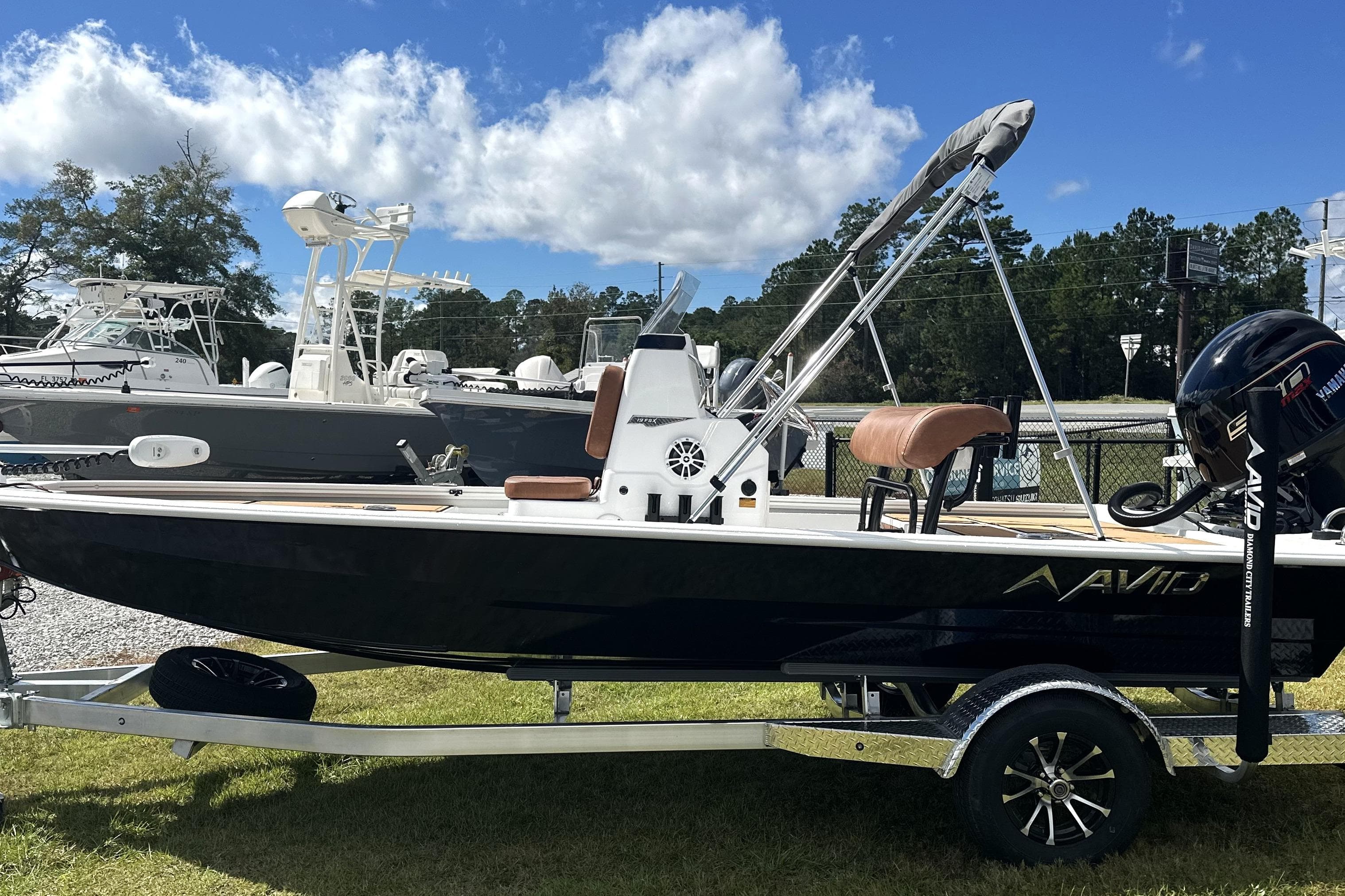2026 Avid 19 FSX boat on trailer, parked outdoors under a blue sky.