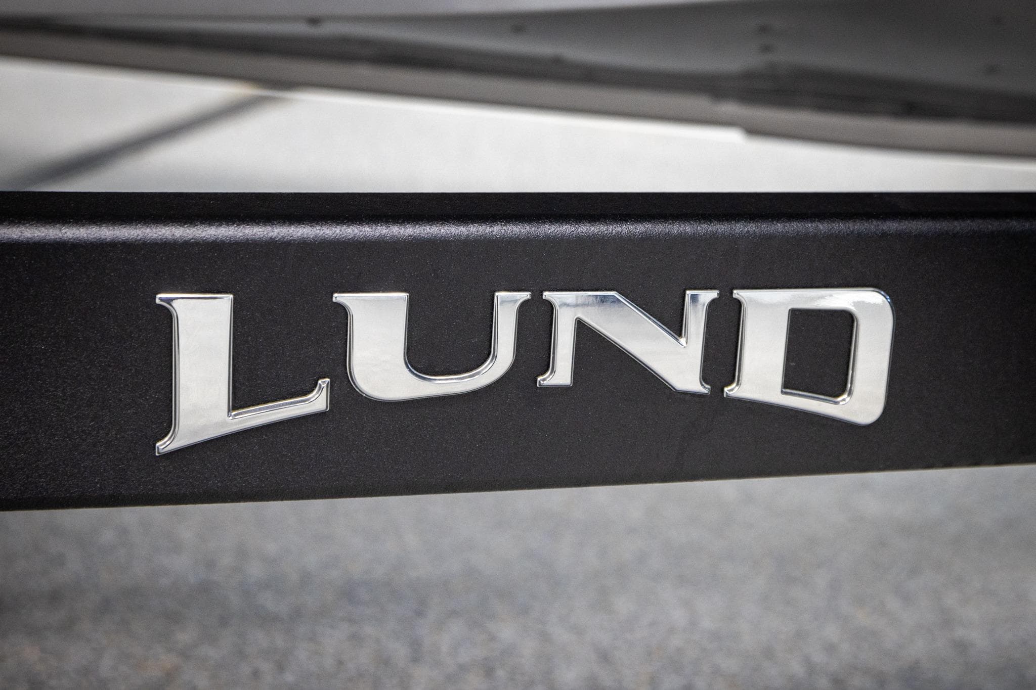 Chrome "Lund" logo on 2026 Lund 2075 Impact XS boat.