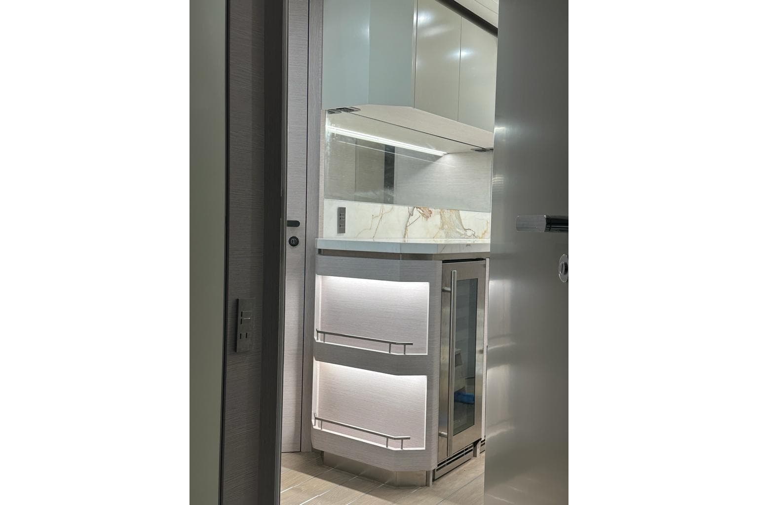 Modern kitchen interior of 2024 Uniesse Exuma HTC5p yacht, featuring sleek cabinetry and lighting.
