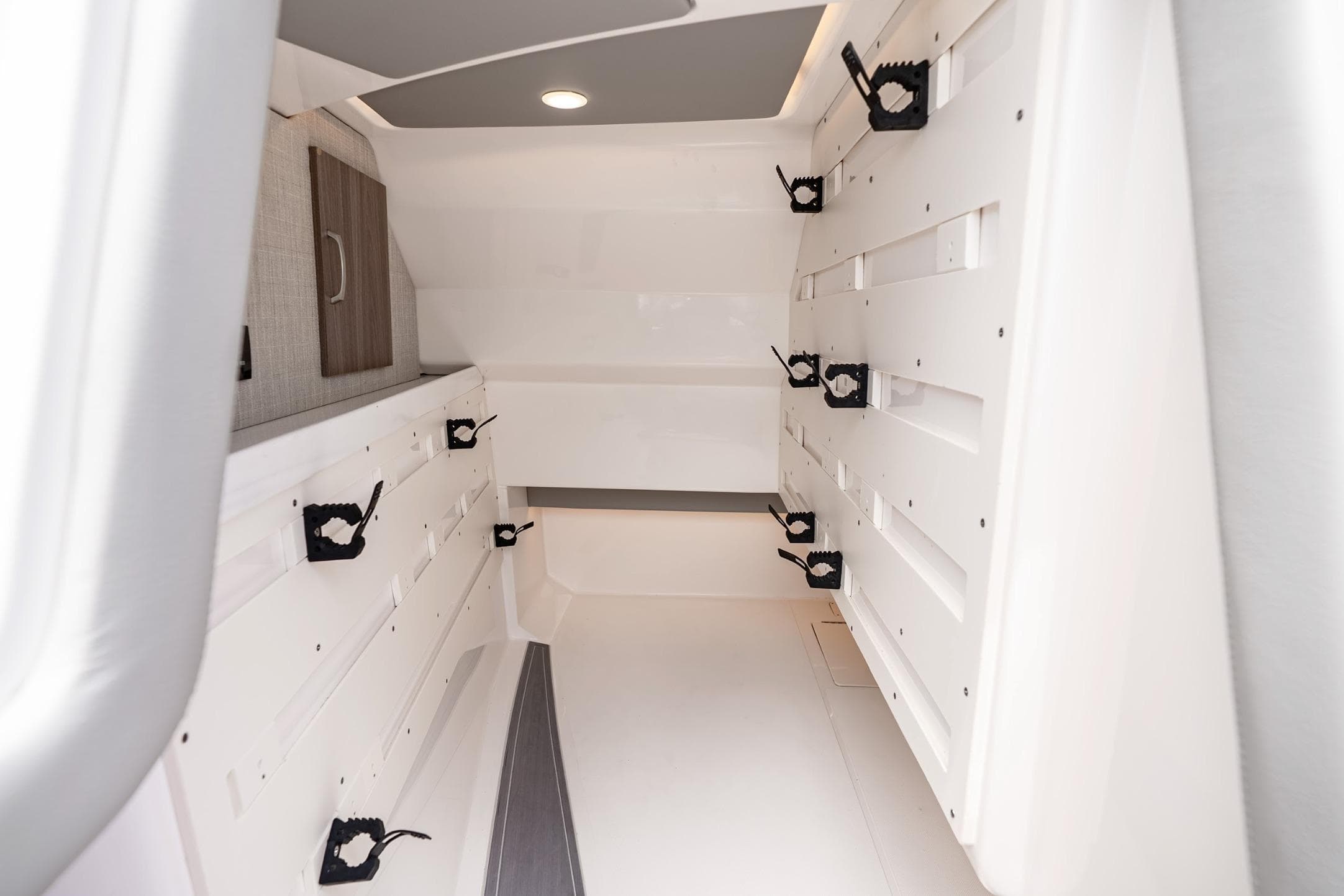 2023 Regal LX36 boat interior storage area with rod holders and cabinetry.