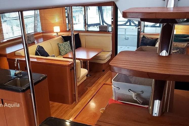 Luxurious interior of a 2014 Aquila 48 yacht with elegant seating and wooden finishes.