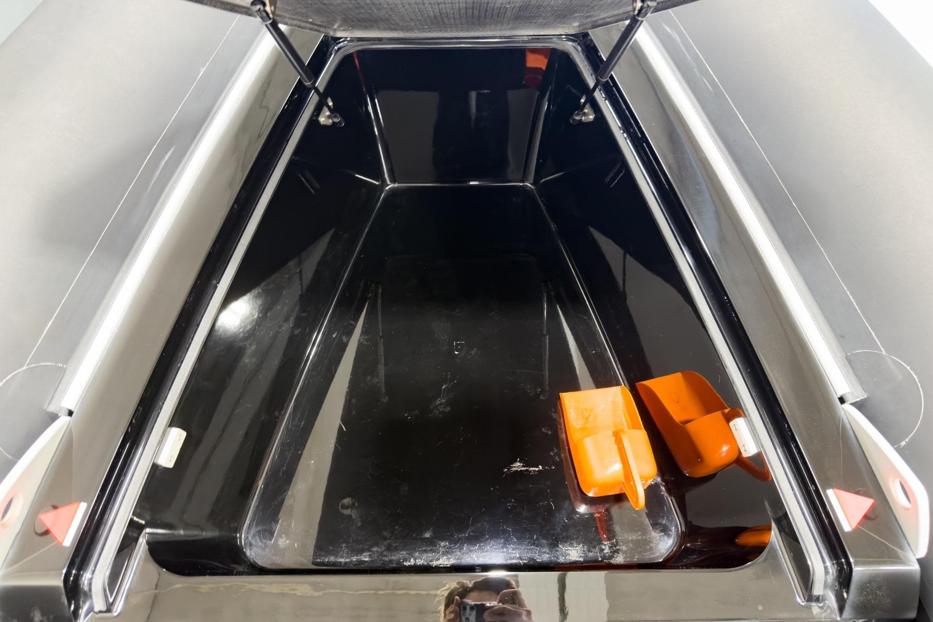 Open storage compartment of 2016 Goldfish 29 Sport boat with orange accessories.