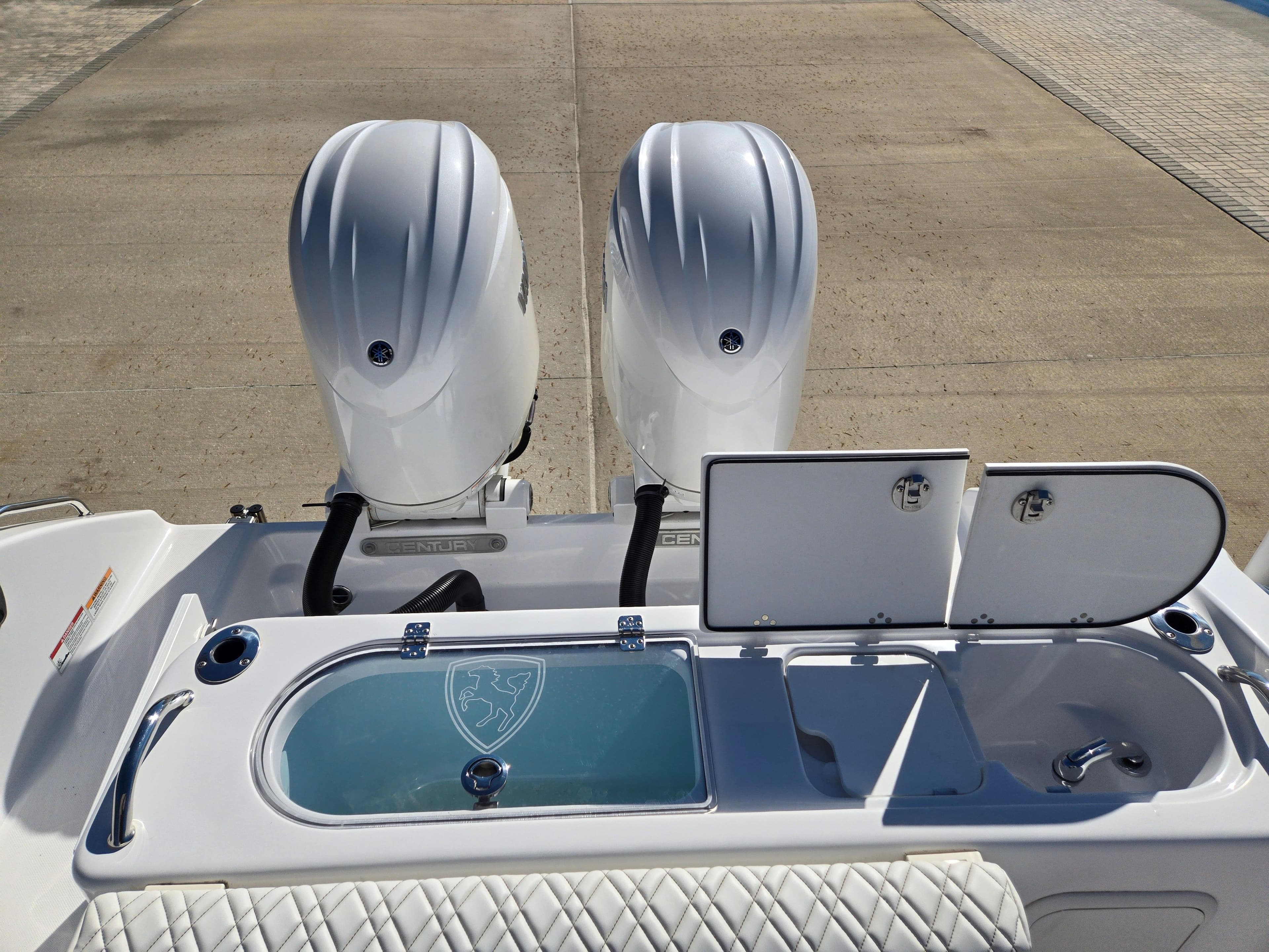 2024 Century 2600 boat with dual outboard engines and storage compartments.