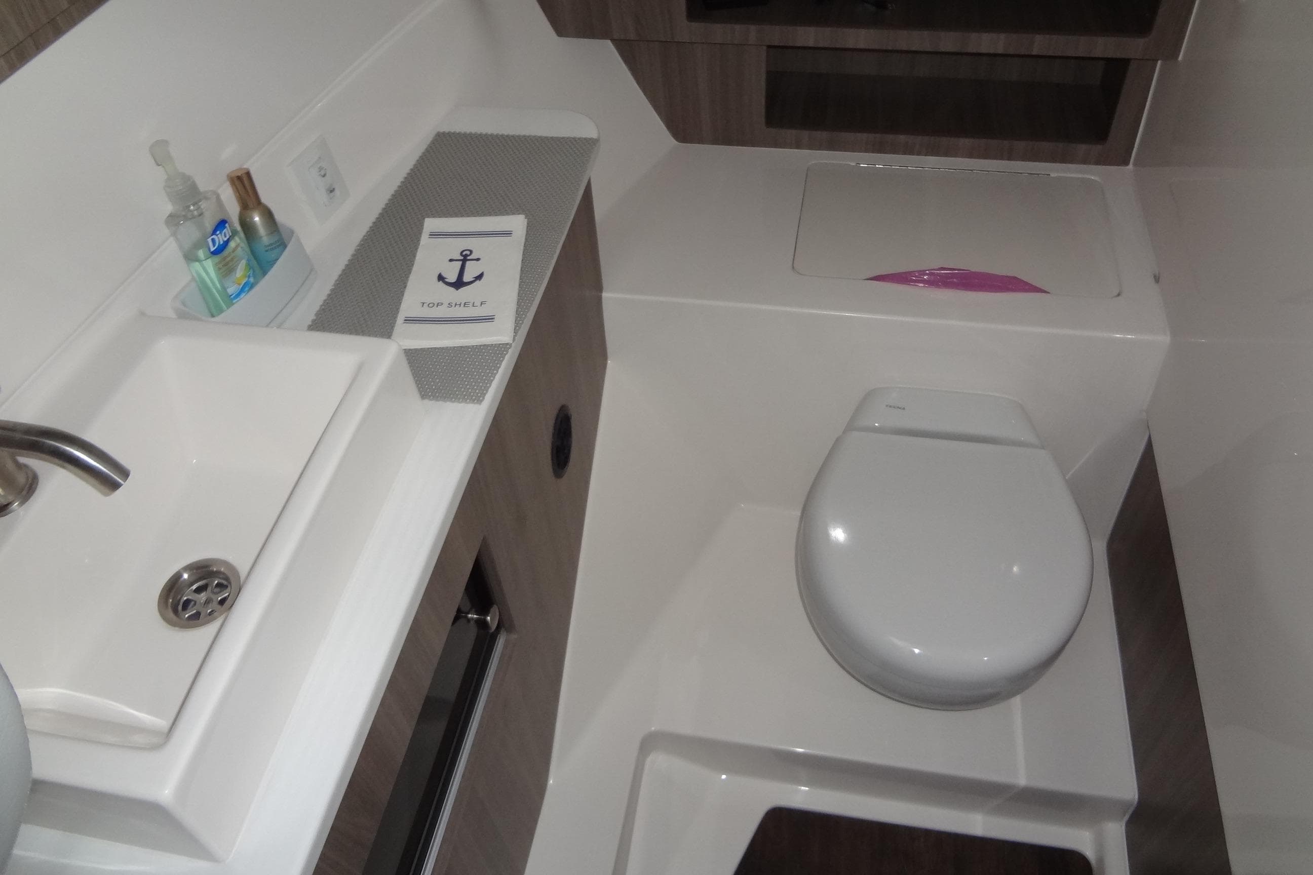 2022 Regal LS36 boat bathroom with sink, toilet, and toiletries.