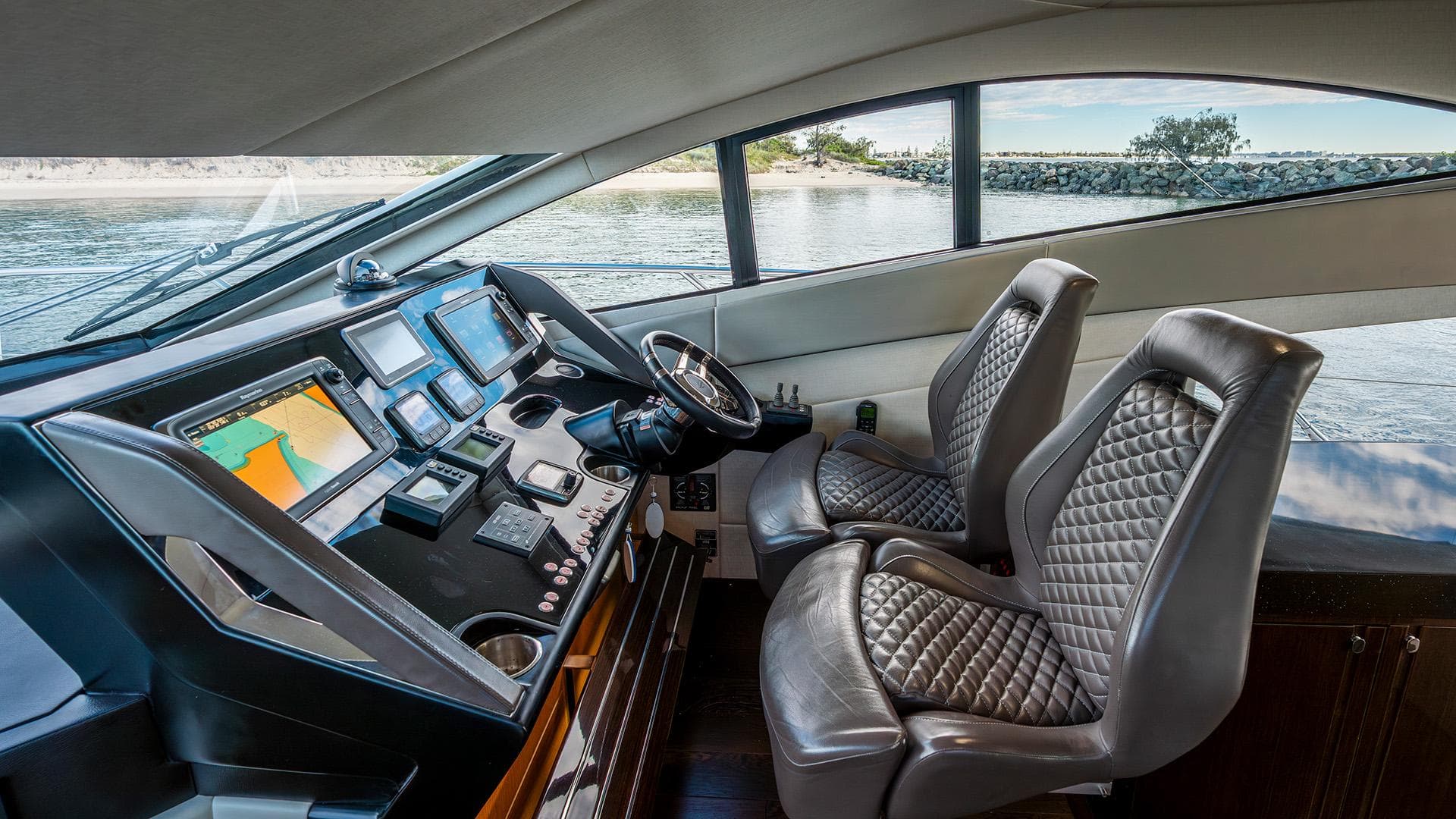 Luxurious 2014 Sunseeker Manhattan 55 yacht cockpit with modern navigation equipment and leather seats.