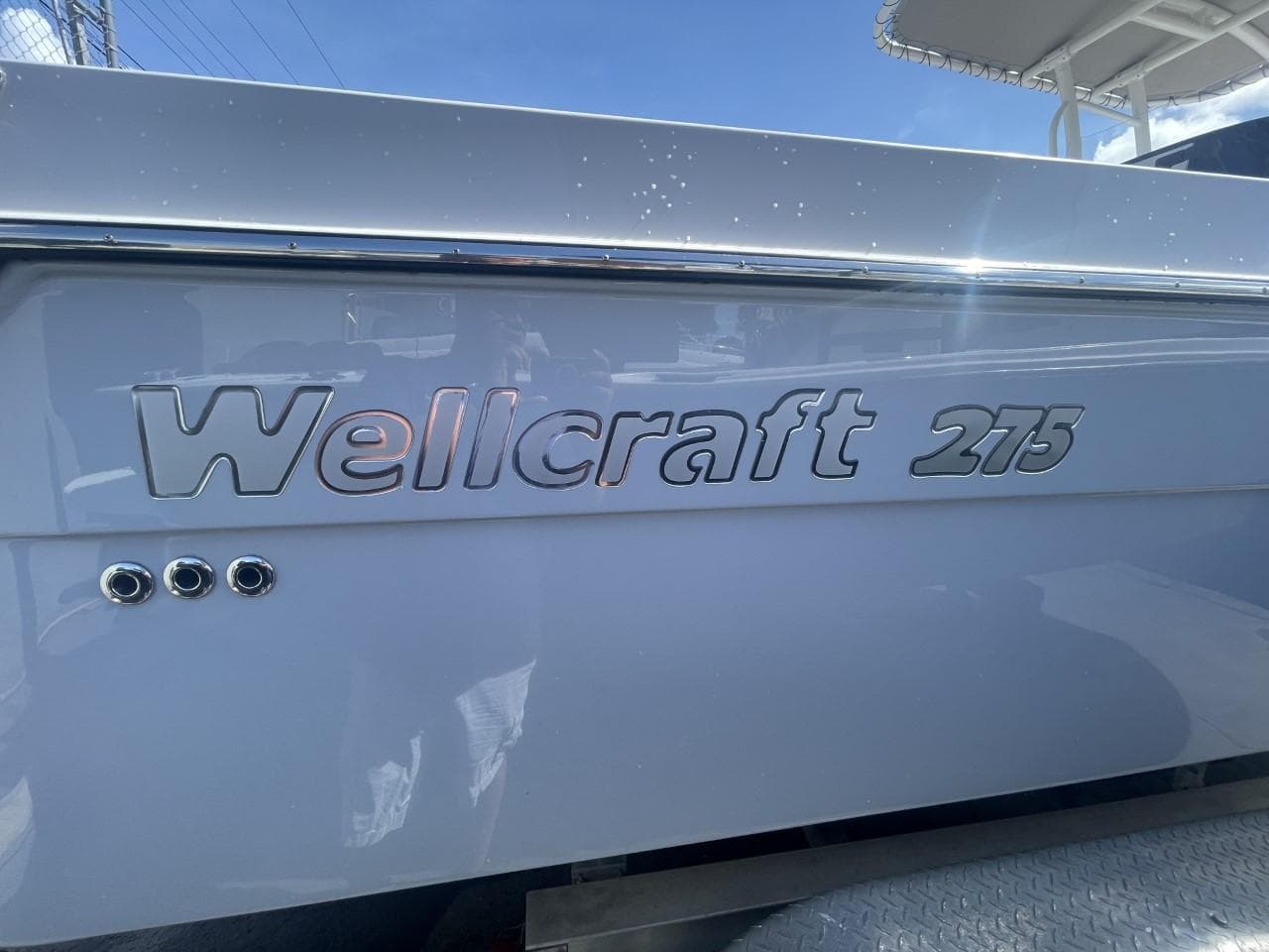 2022 Wellcraft 275cc boat side view with logo and chrome accents.