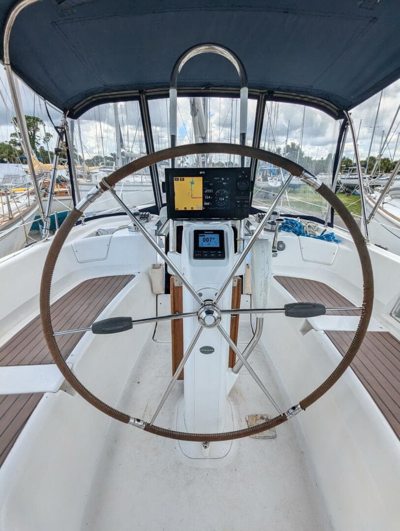 2007 Hunter 45 Center Cockpit with navigation equipment and steering wheel, docked at marina.