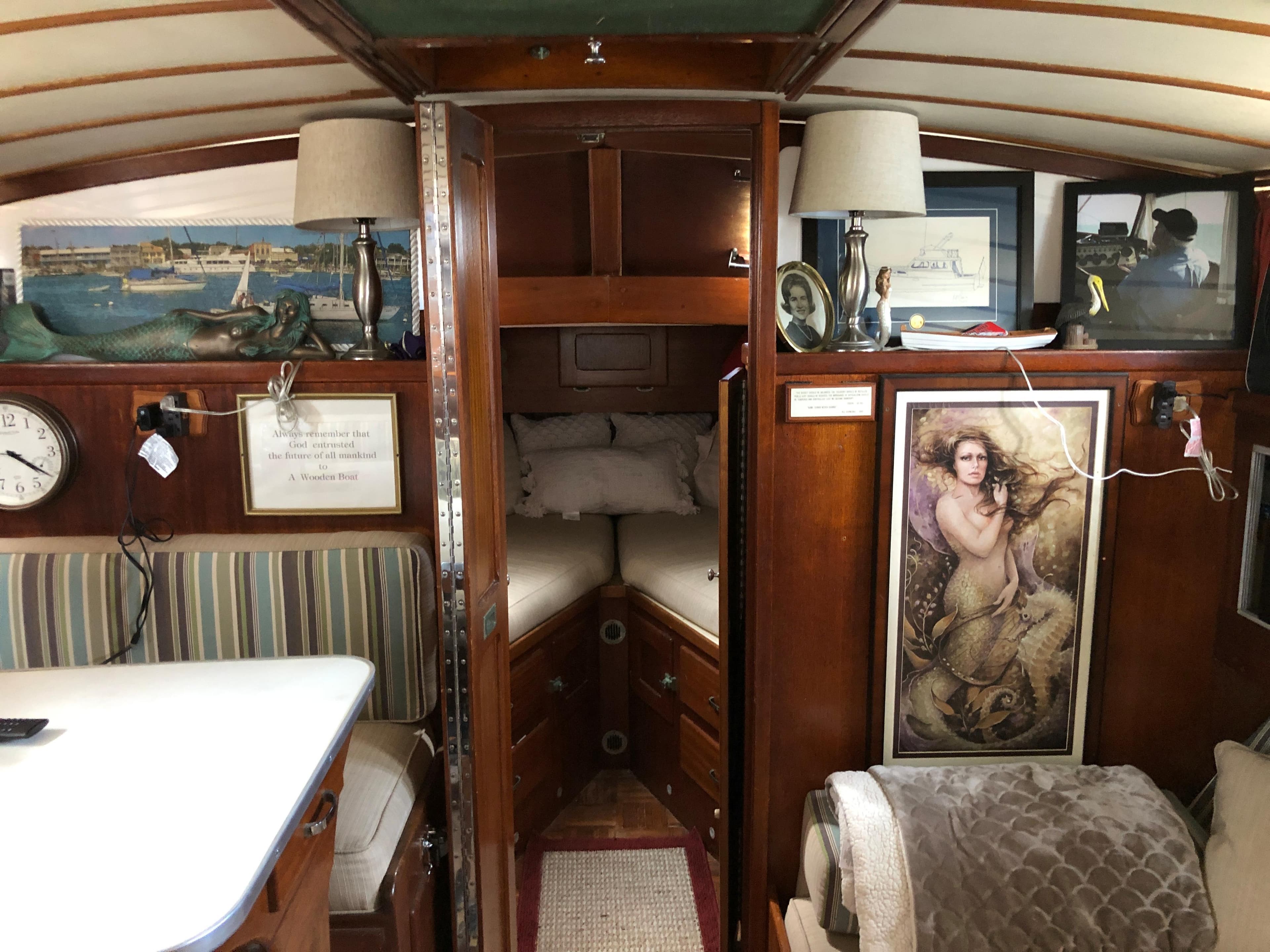 1963 Egg Harbor Convertible Cruiser interior with cozy cabin, nautical decor, and vintage artwork.
