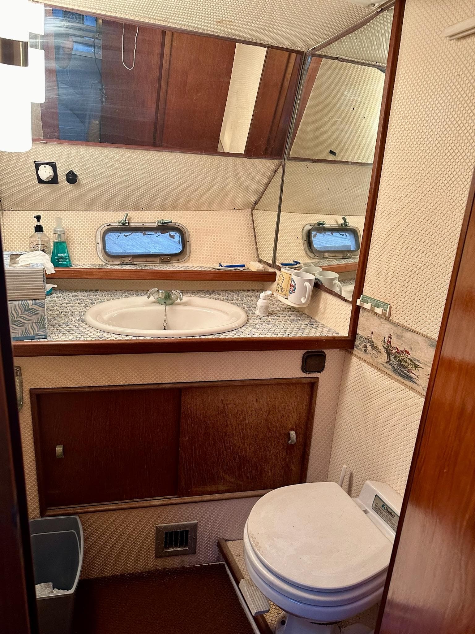 Bathroom interior of 1986 Cytra Bavaria 40 yacht with sink, mirror, and toilet.