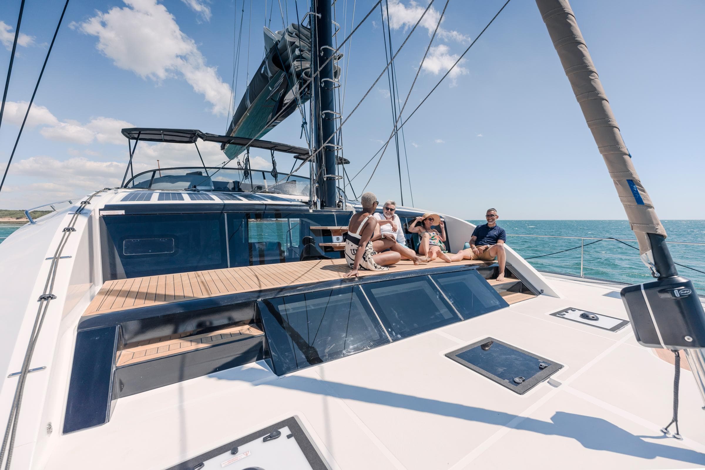 People relaxing on the deck of a 2025 Privilege Signature 650 yacht at sea.