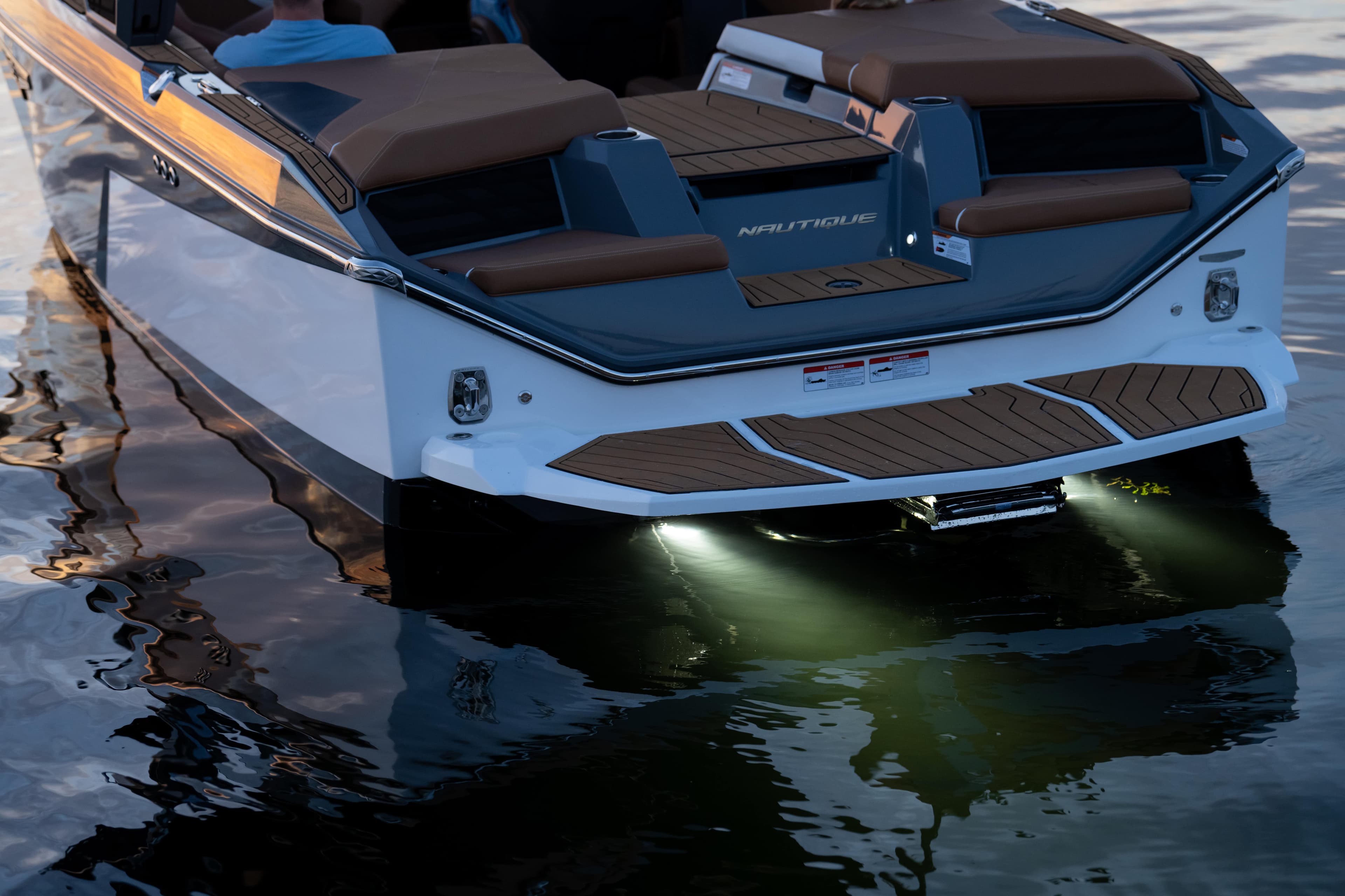 2026 Nautique S21 boat with illuminated stern on calm water.