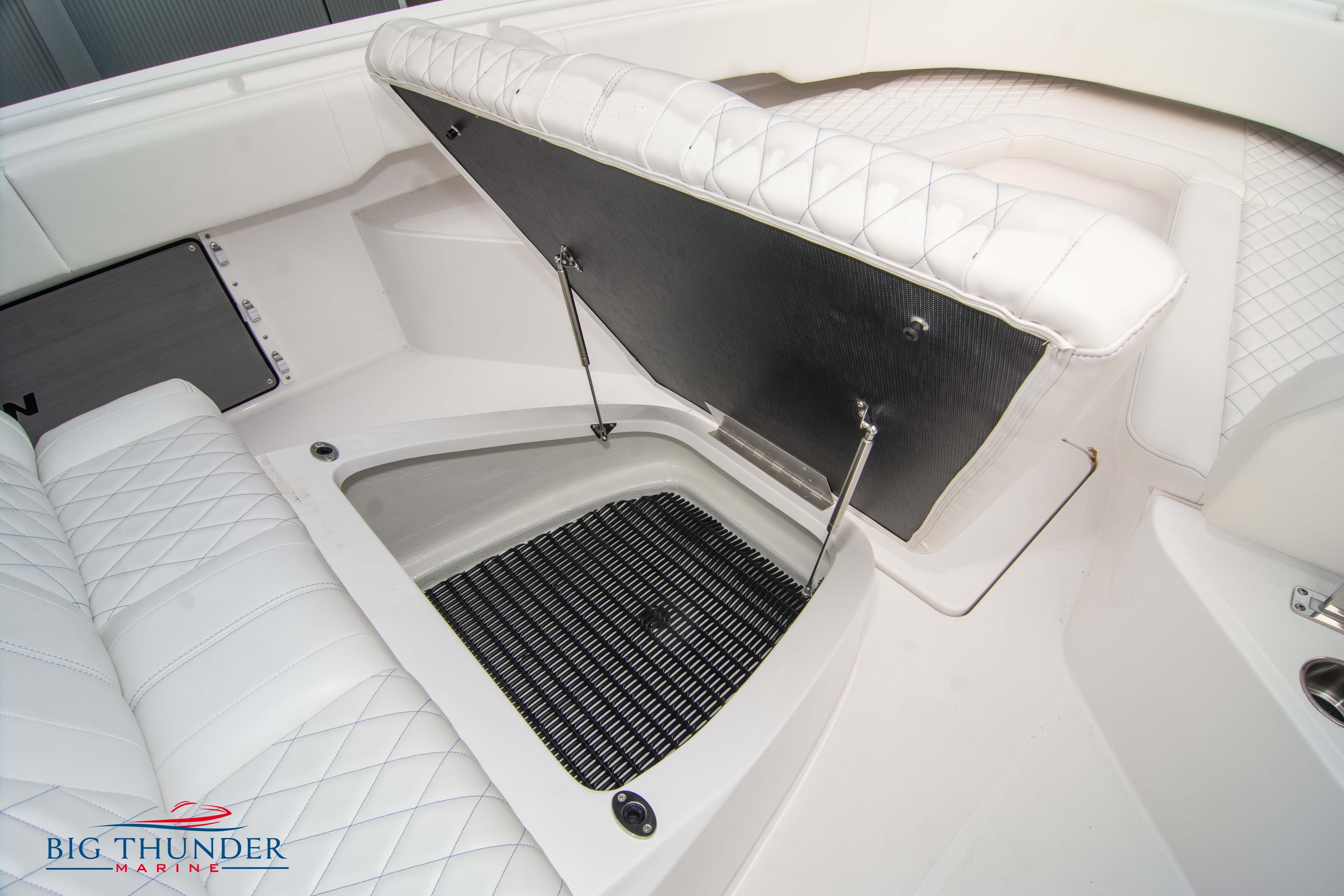 2023 Fountain 34 CC boat interior with open storage compartment and white quilted seating.