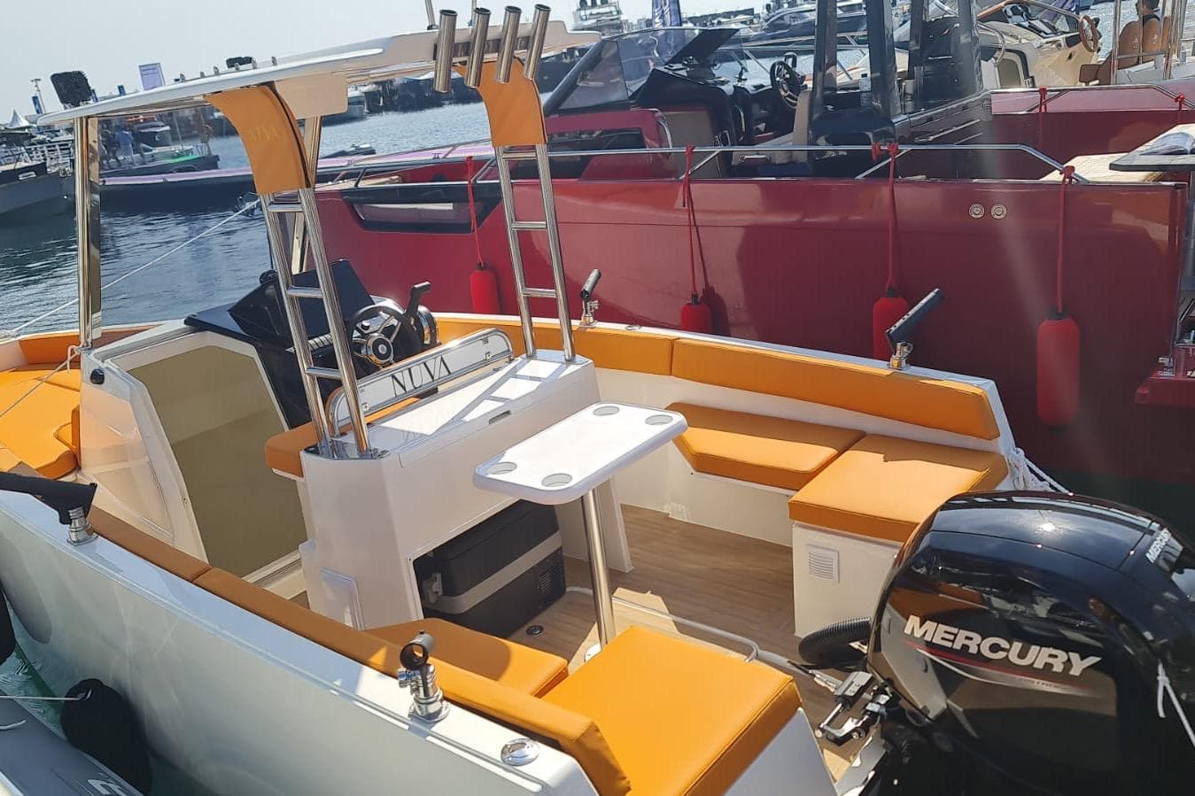 2025 NUVA YACHTS M6 Fisher with orange seating and Mercury engine at marina.
