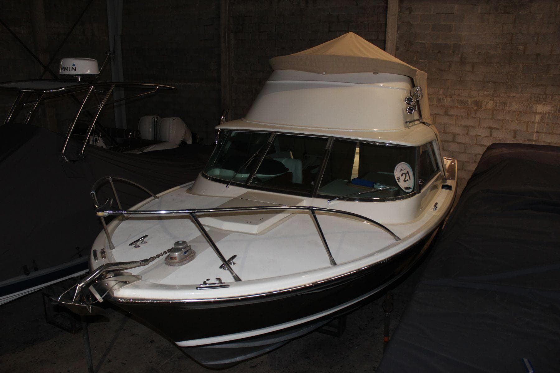 1974 Riva Bertram 25 Sportfisherman boat in a dimly lit storage area.