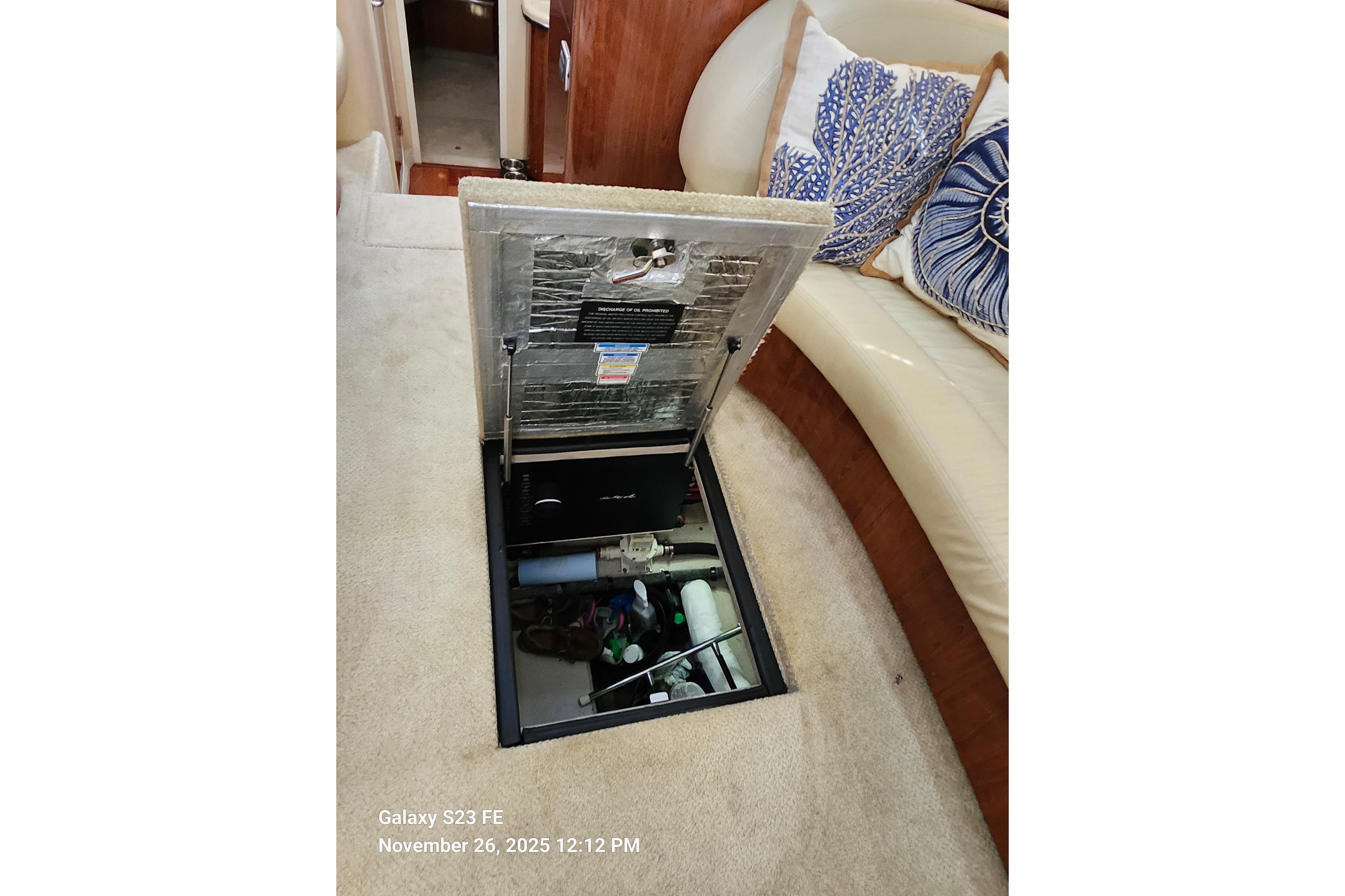 Open hatch in 2004 Sea Ray 390 Motor Yacht interior, revealing storage compartment.