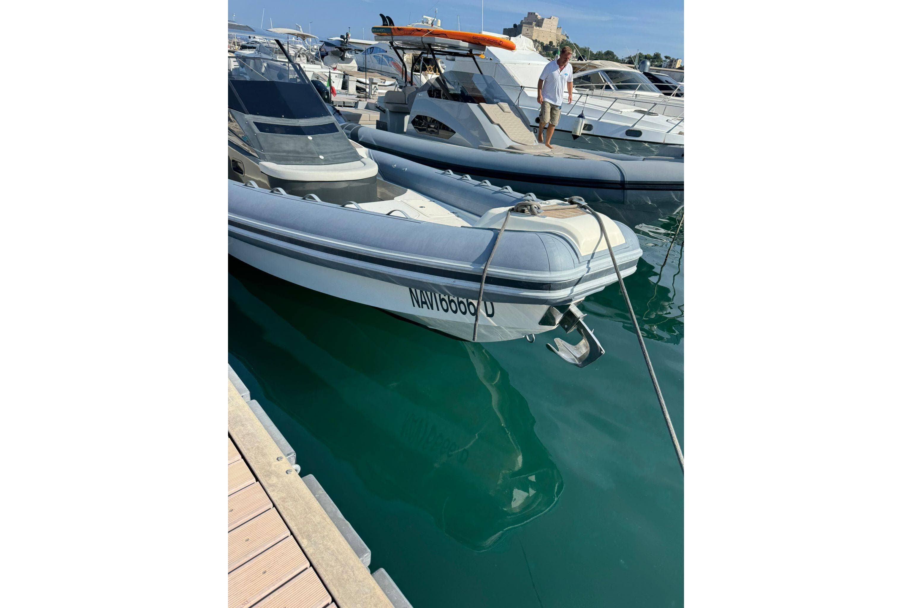 2020 Lomac GranTurismo 12.0 boat docked in a marina, with clear blue water.