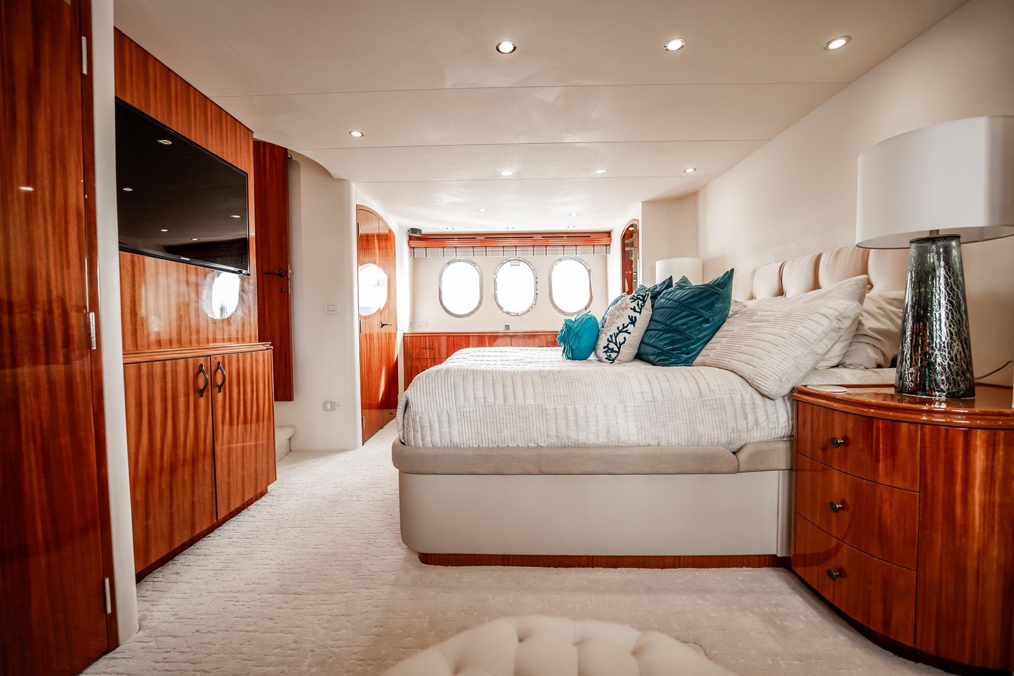 Luxurious bedroom interior of 2012 Hatteras 80 Motor Yacht with elegant wood finishes.