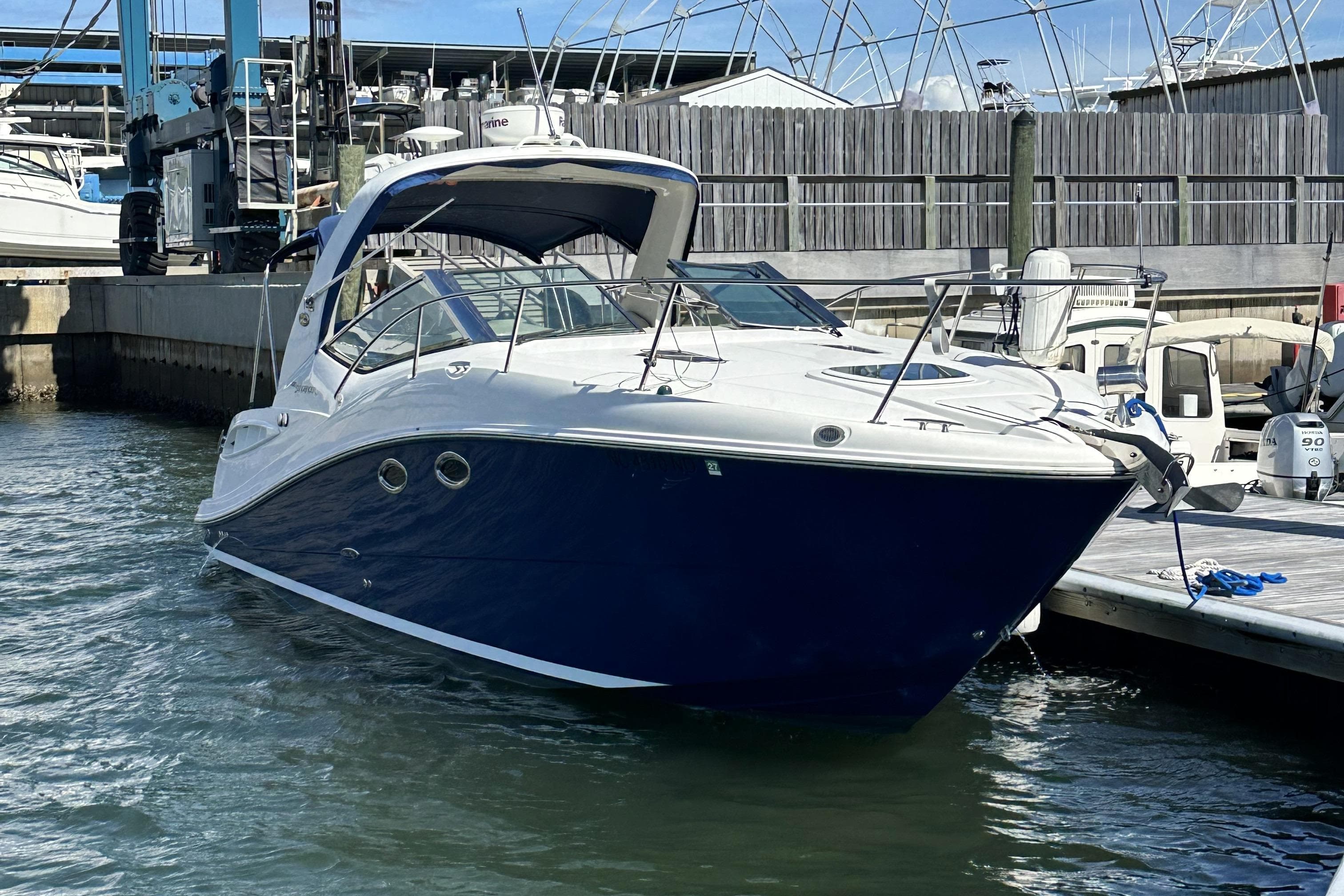 2008 Sea Ray 290 Sundancer docked at marina, featuring sleek design and blue hull.