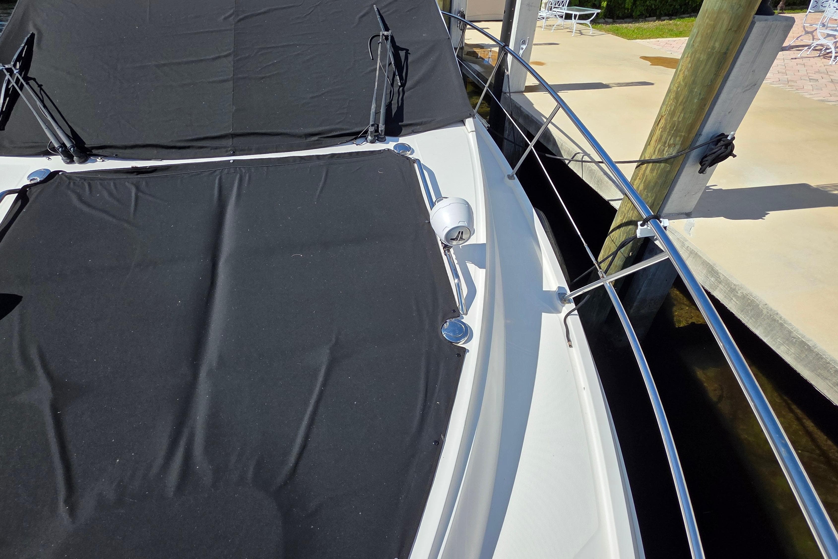 2016 Sea Ray Sundancer 400 yacht with black cover docked at marina.