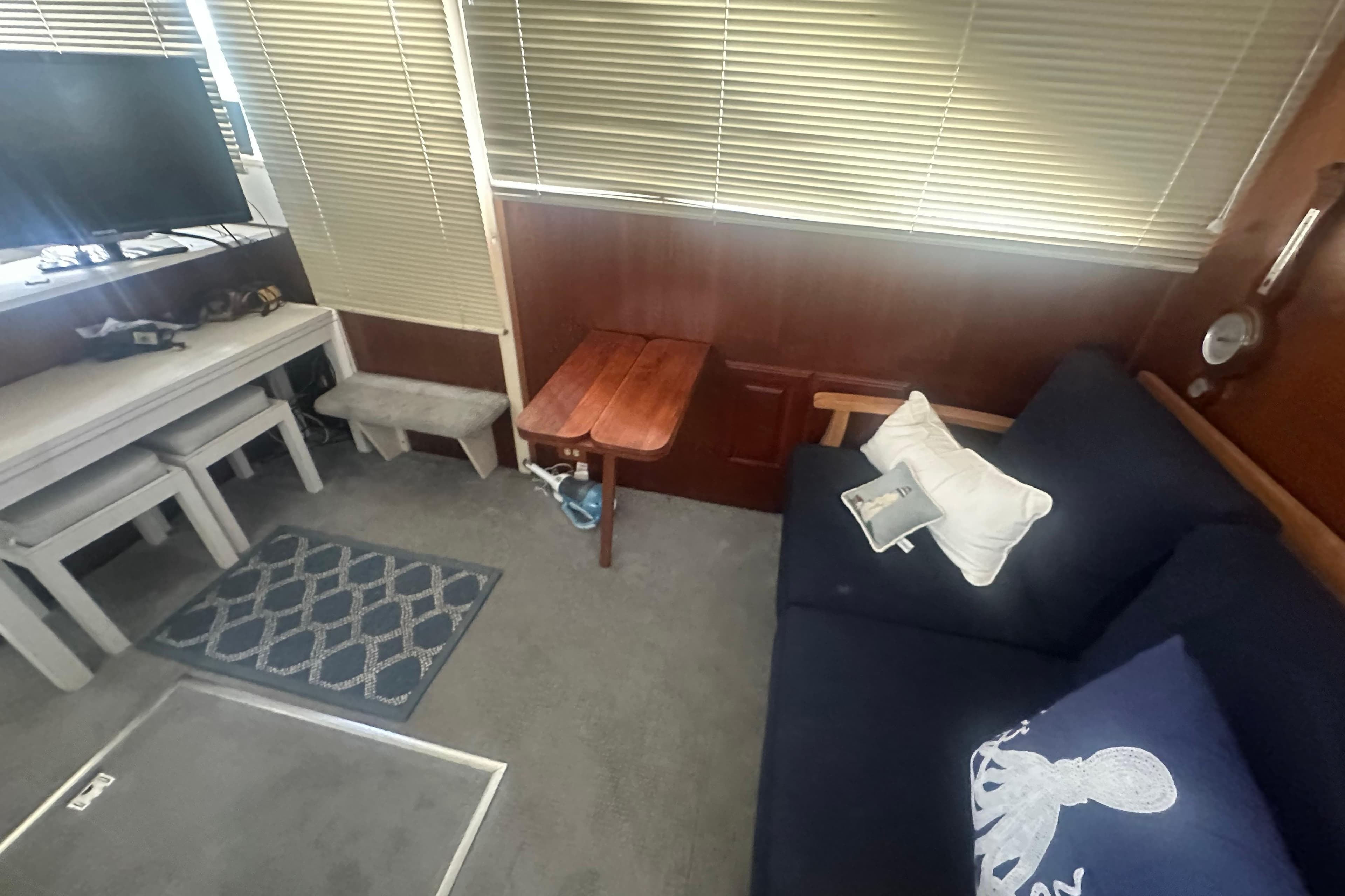 1971 Chris-Craft Commander 42 interior with sofa, table, TV, and nautical decor.