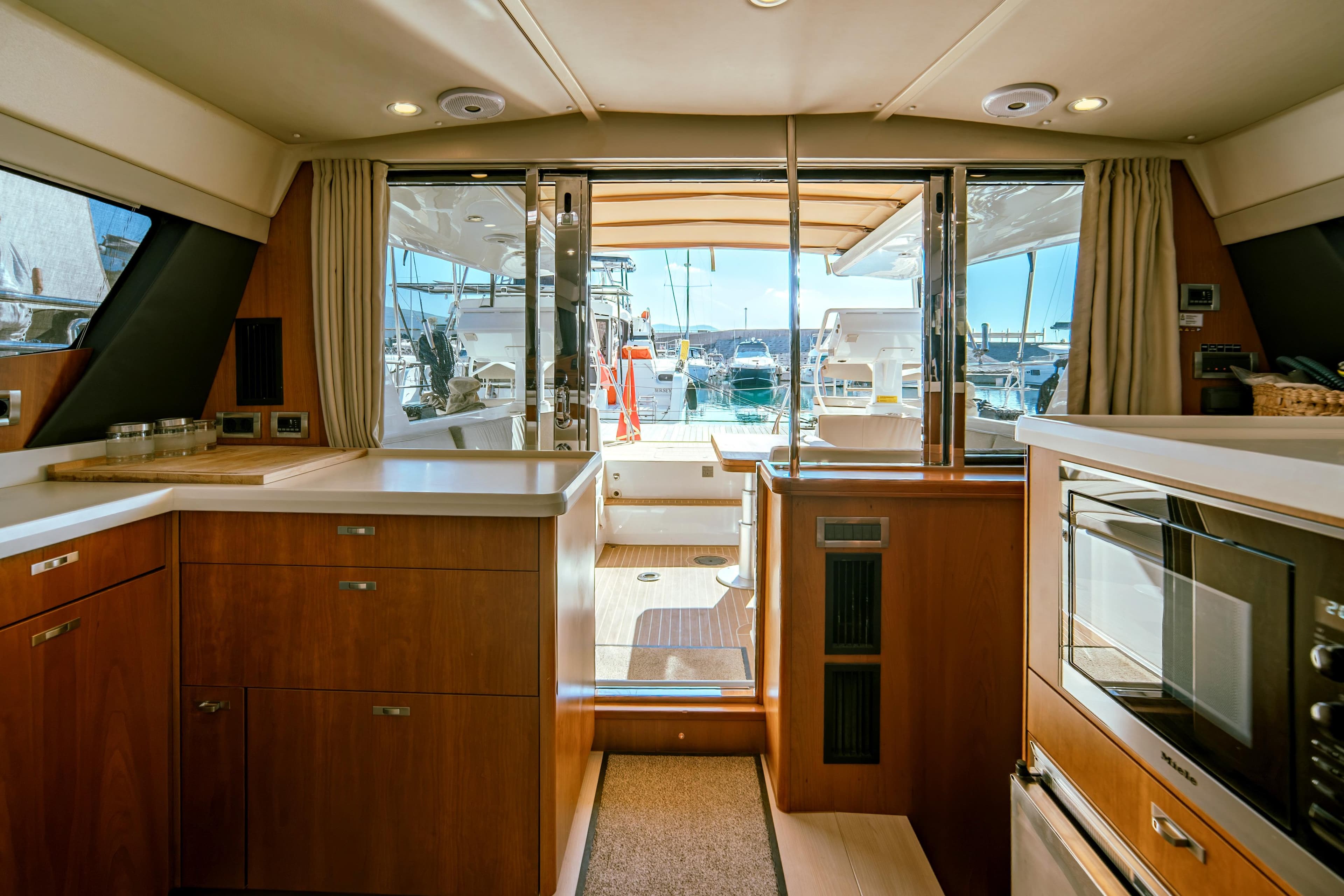Luxurious interior of 2016 Moody 54 DS yacht with modern kitchen and marina view.