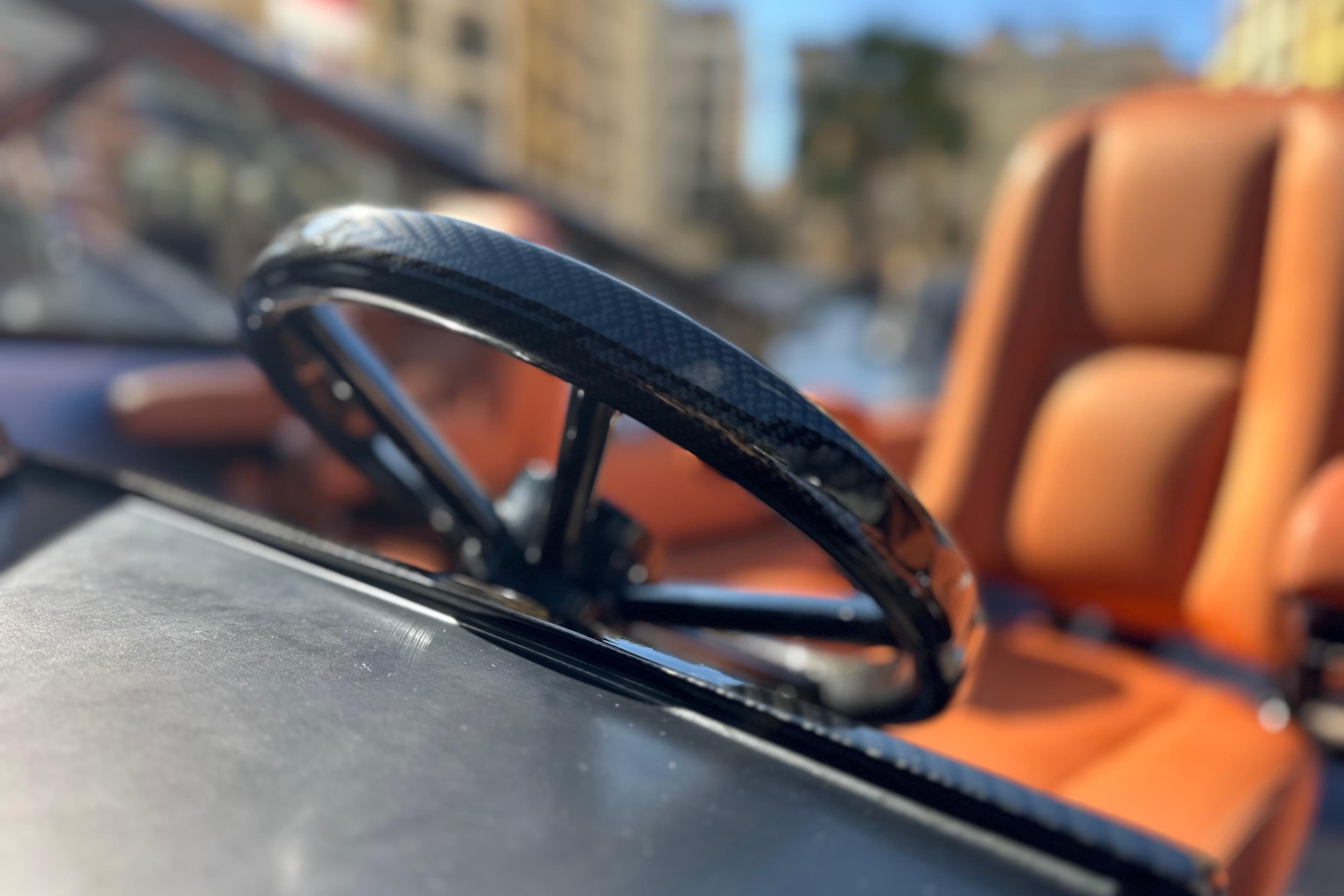 Steering wheel of a 2014 Wajer 38 boat with leather seats in the background.