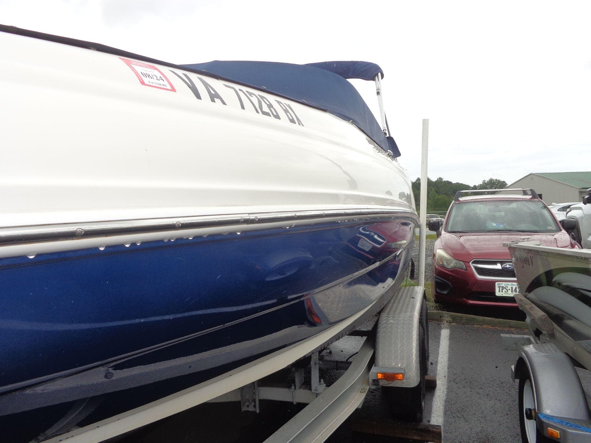 2007 Sea Ray 200 Sundeck boat on trailer in parking lot.
