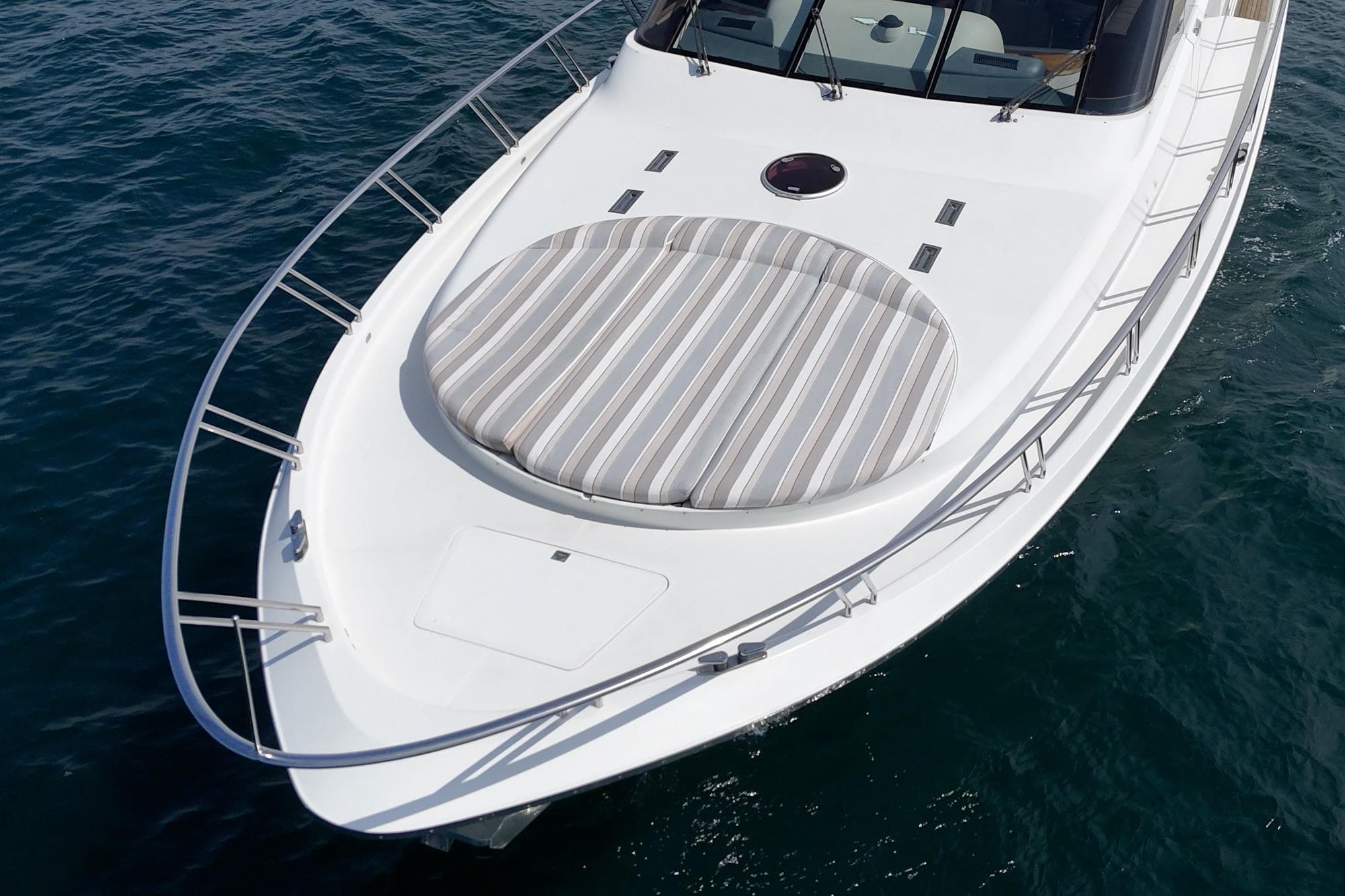 Nordlund 66 yacht bow with striped sun pad, 1995 model, on calm blue water.