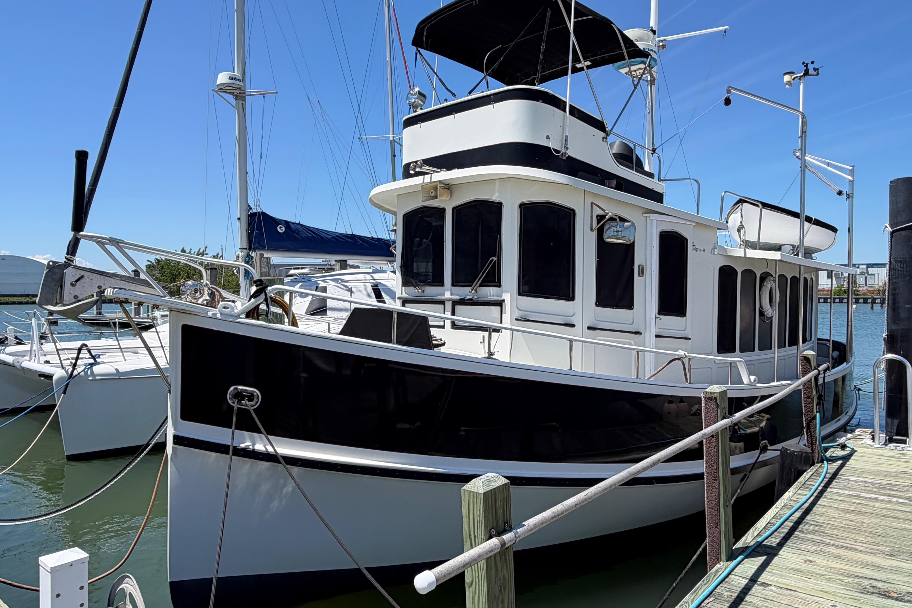 1985 Gozzard PILGRIM boat docked at marina under clear blue sky.