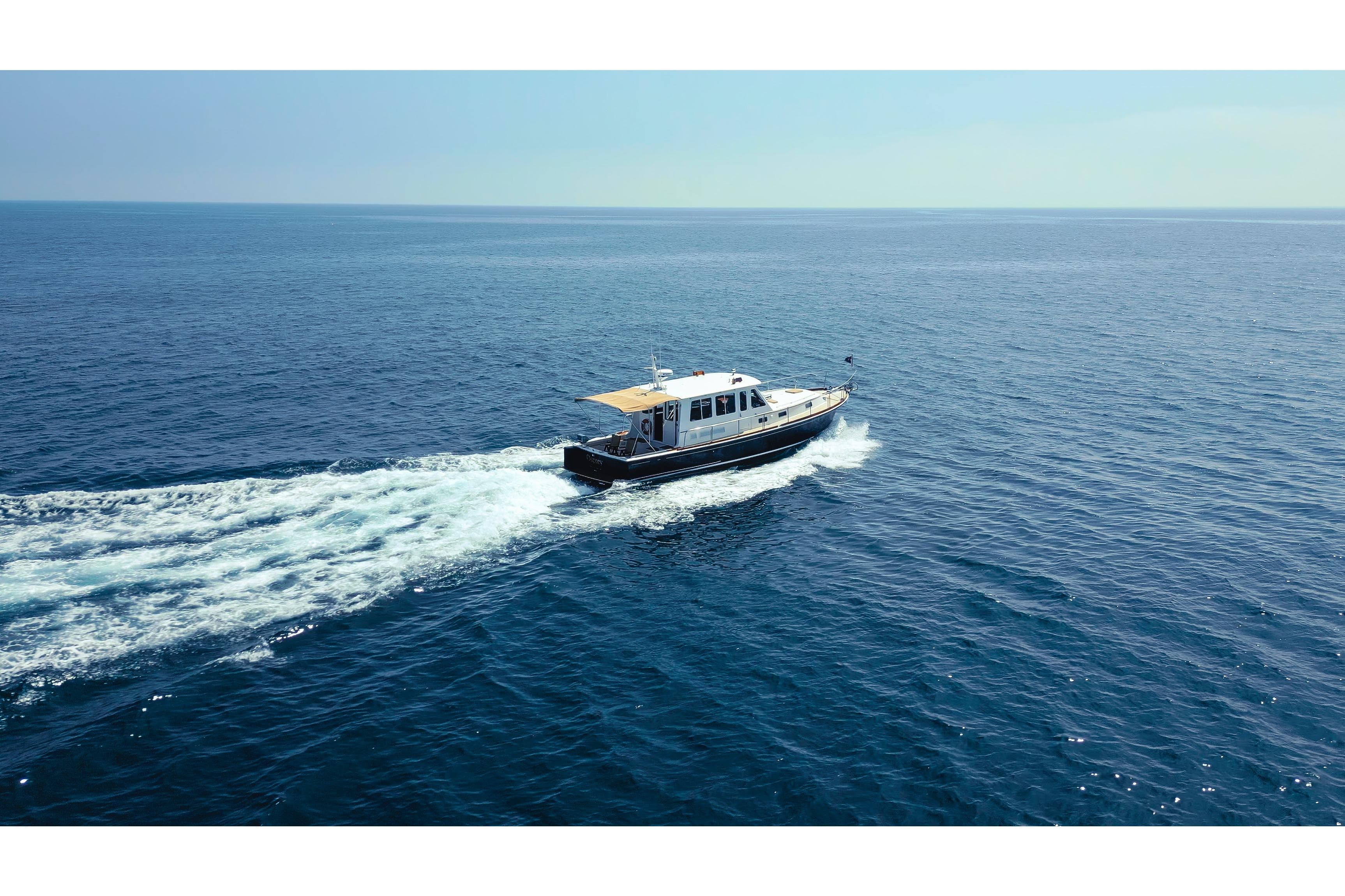 1998 Grand Banks 43 Eastbay EX cruising on open sea under clear skies.