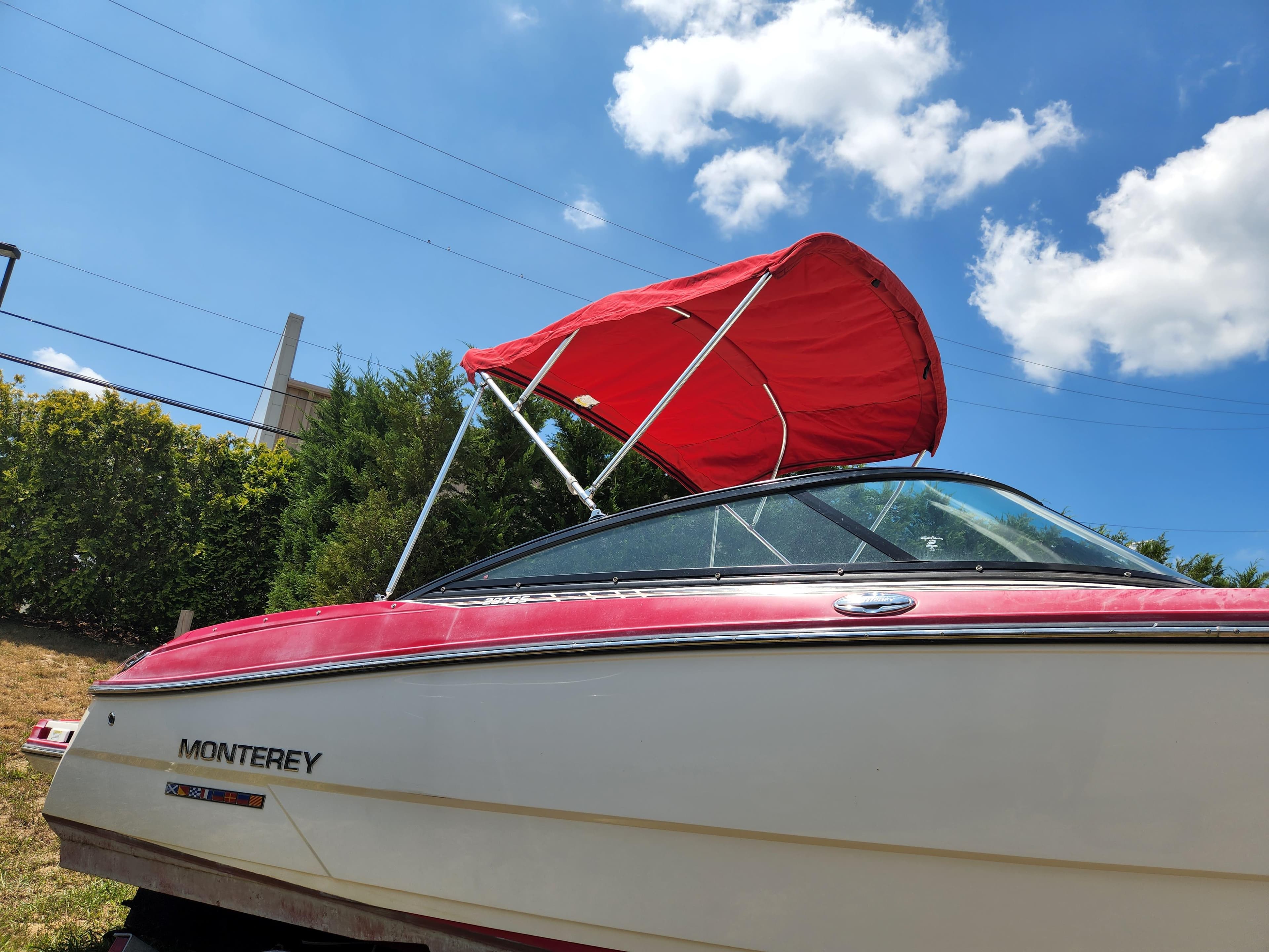 2014 Monterey 234 SS boat with red canopy under blue sky.