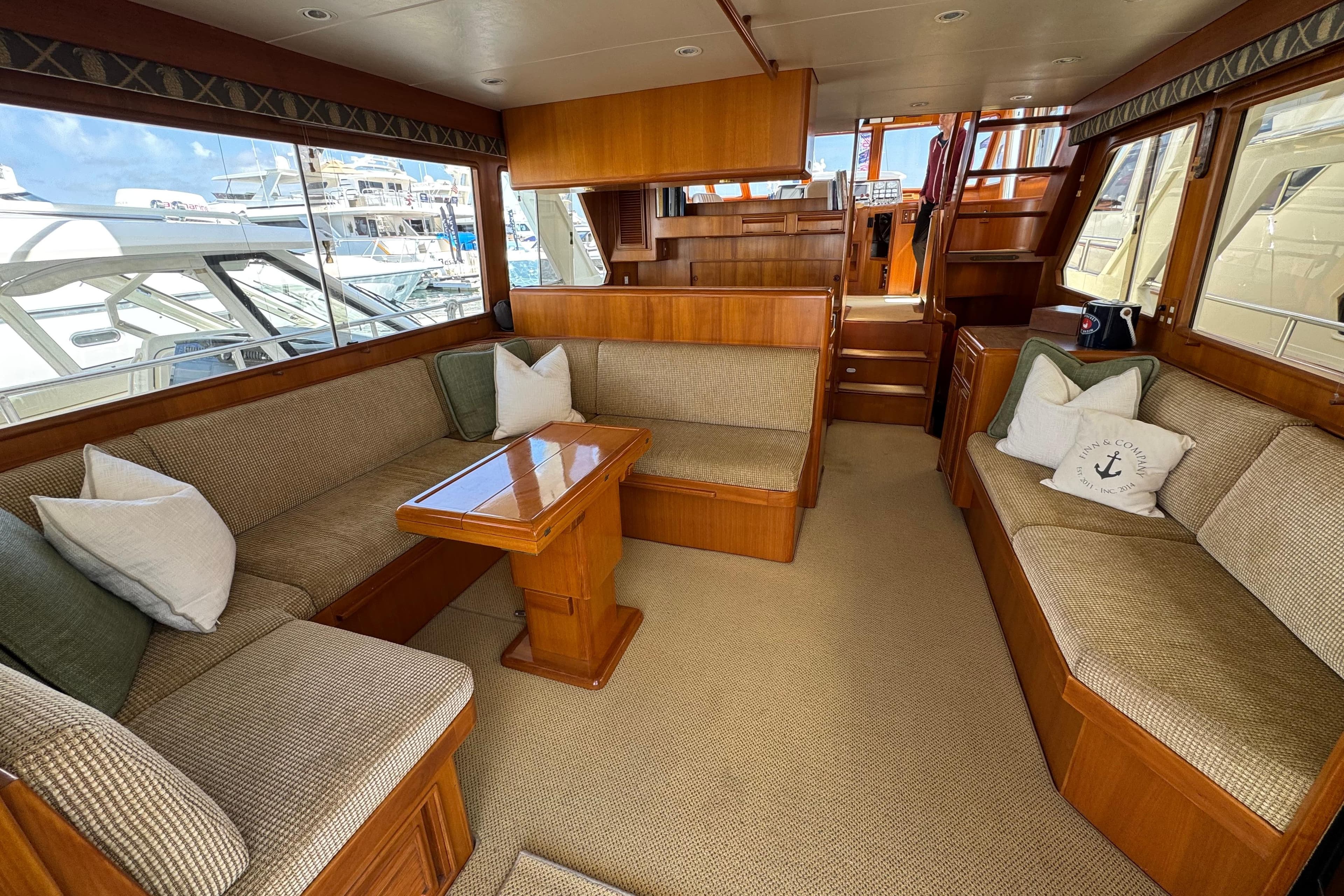 Luxurious interior of 1999 Offshore Yachts 52 Pilothouse with plush seating and wooden accents.