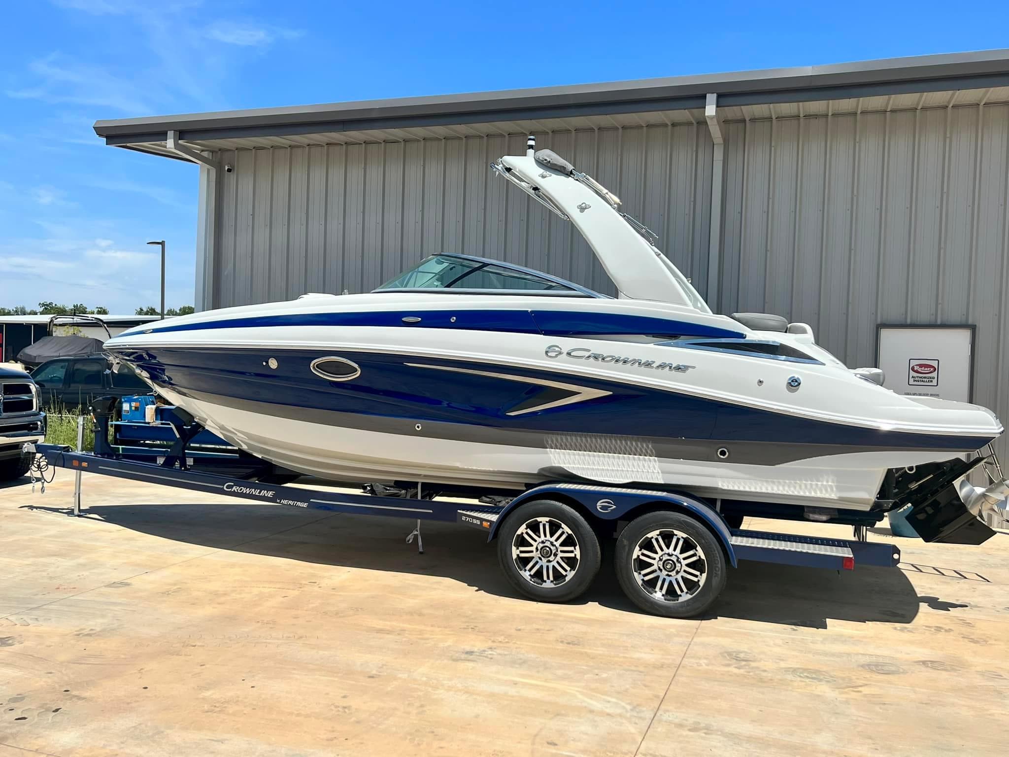 2024 Crownline 270SS boat on trailer, parked outside a building.