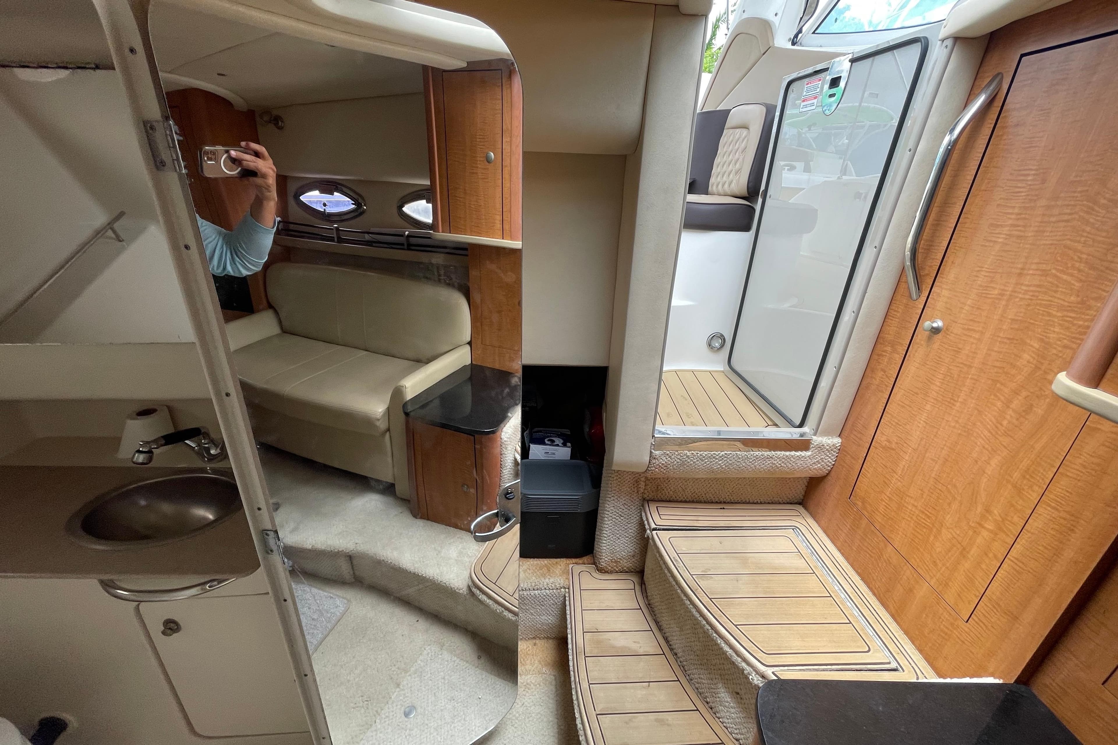 Interior of 2006 Sea Ray 290 Sundancer boat, featuring seating, stairs, and wooden cabinetry.