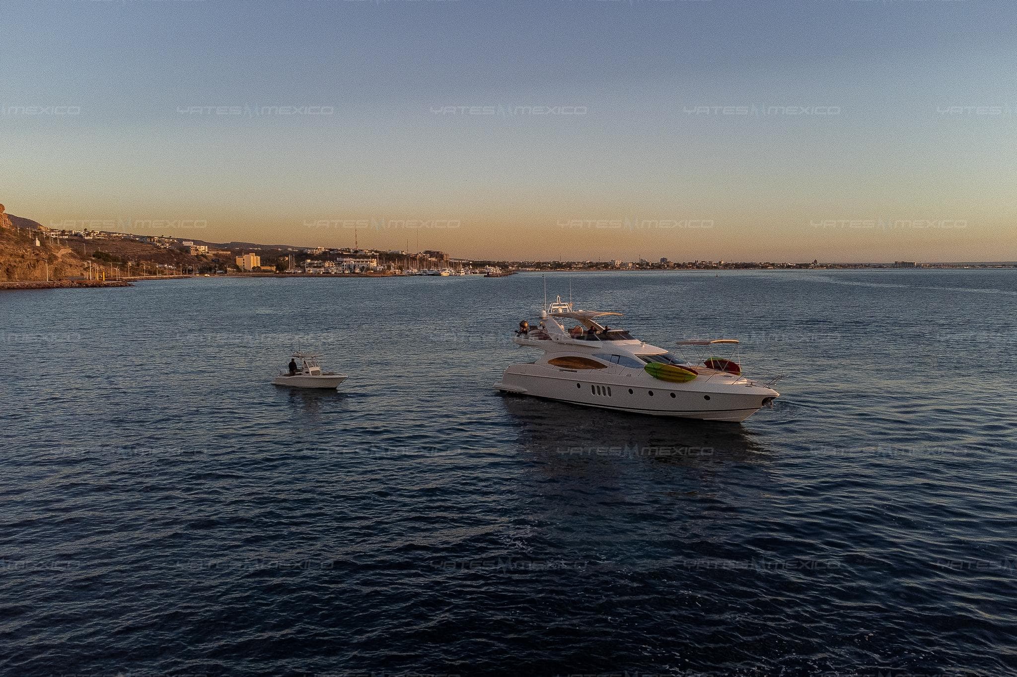 2004 Azimut 68 Plus yacht on calm sea at sunset, near coastline.