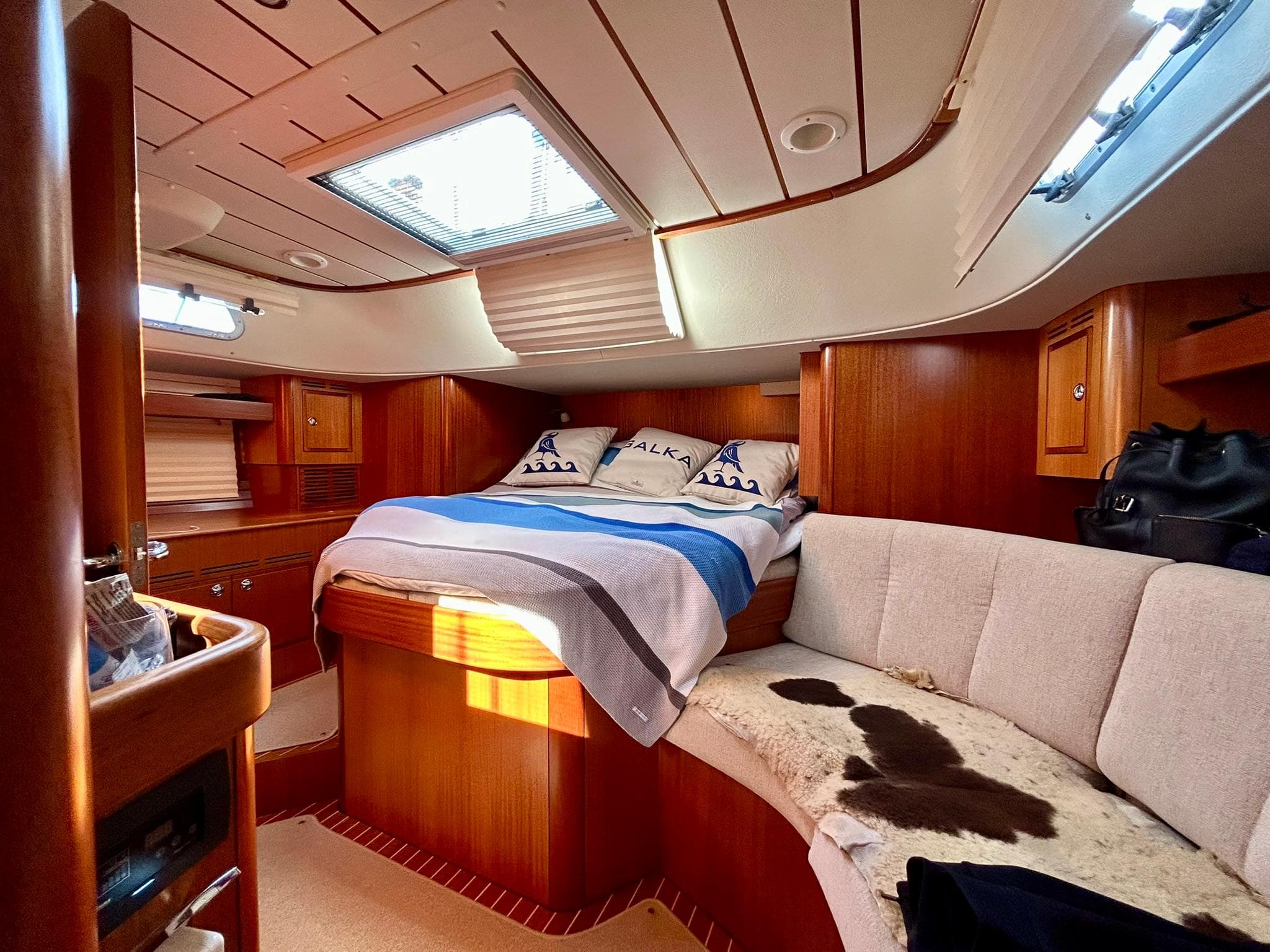 Luxurious 2020 Hallberg-Rassy 44 yacht interior with cozy bed and elegant wood finish.