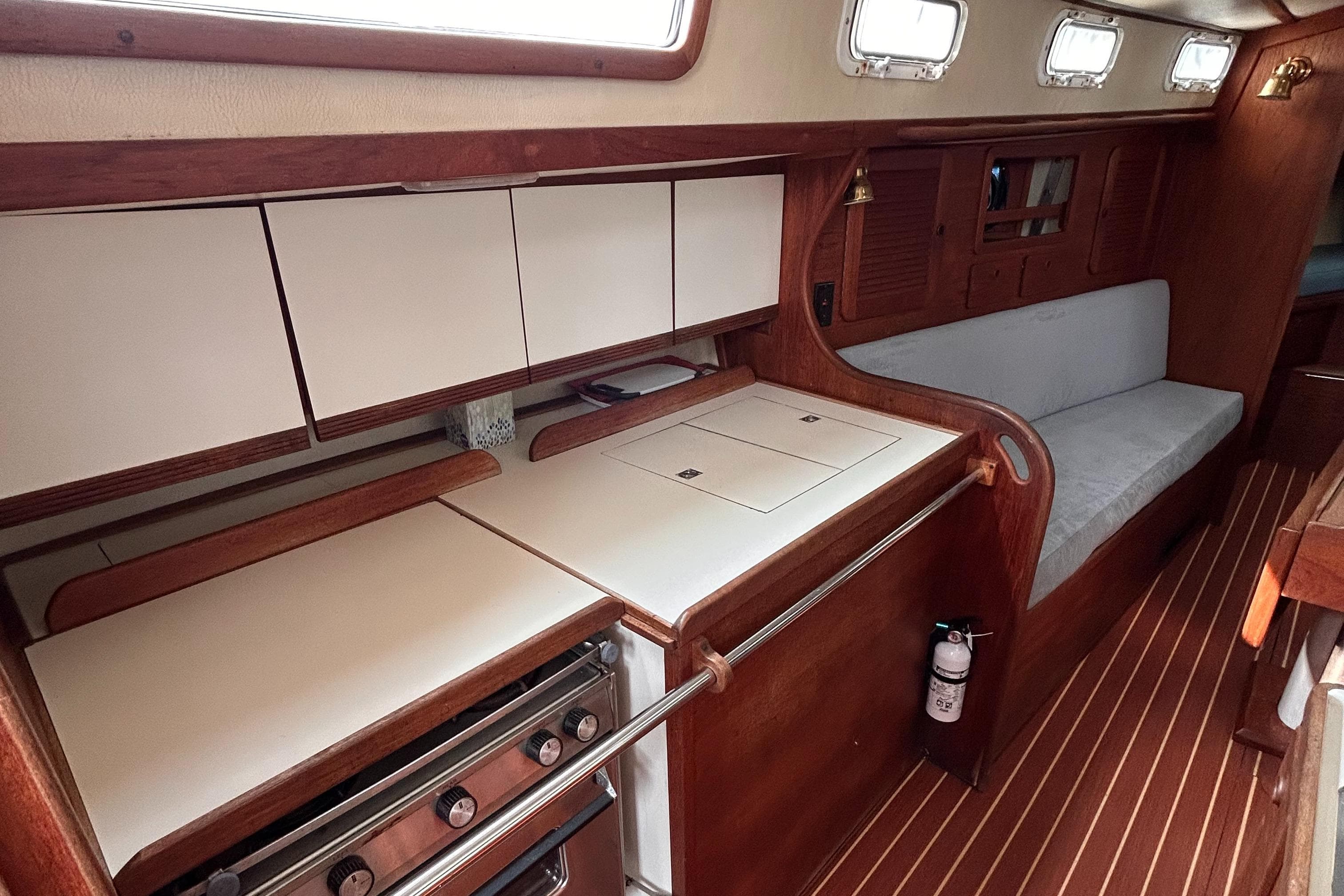 1983 Sabre 38 yacht interior with wooden cabinetry, compact kitchen, and seating area.