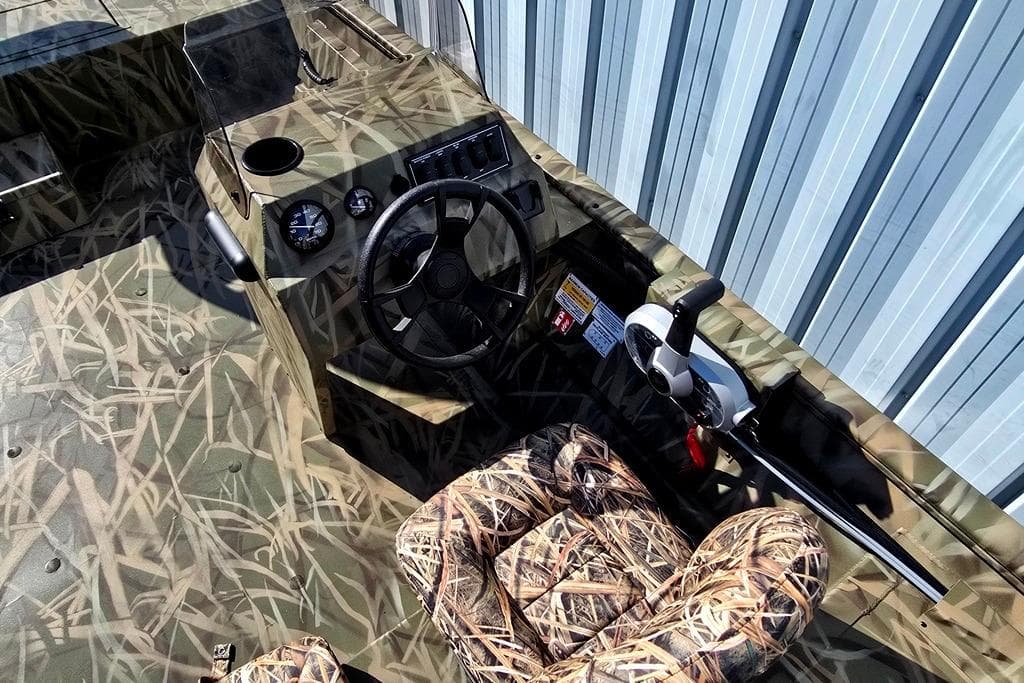 2026 Lowe Roughneck RX2070 SC boat interior with camouflage design and steering console.