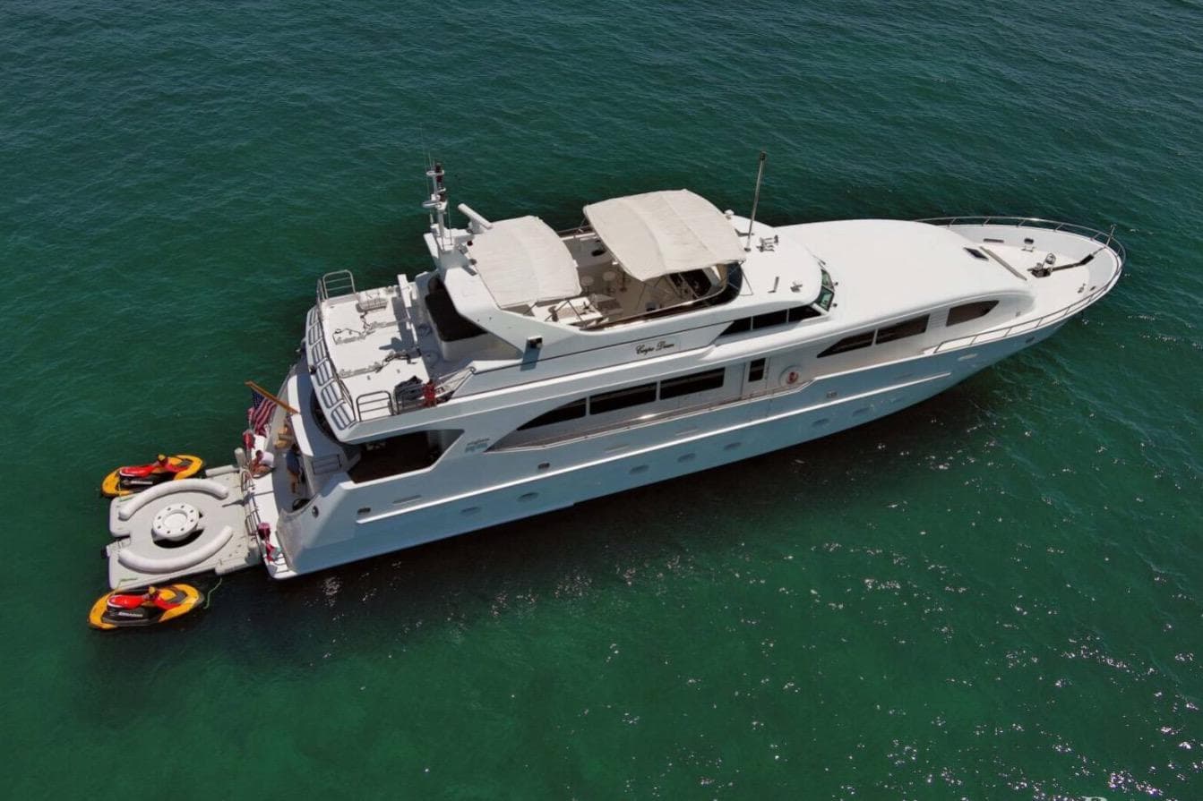 Luxury 2001 Intermarine RPH 95 yacht on clear blue water with jet skis attached.